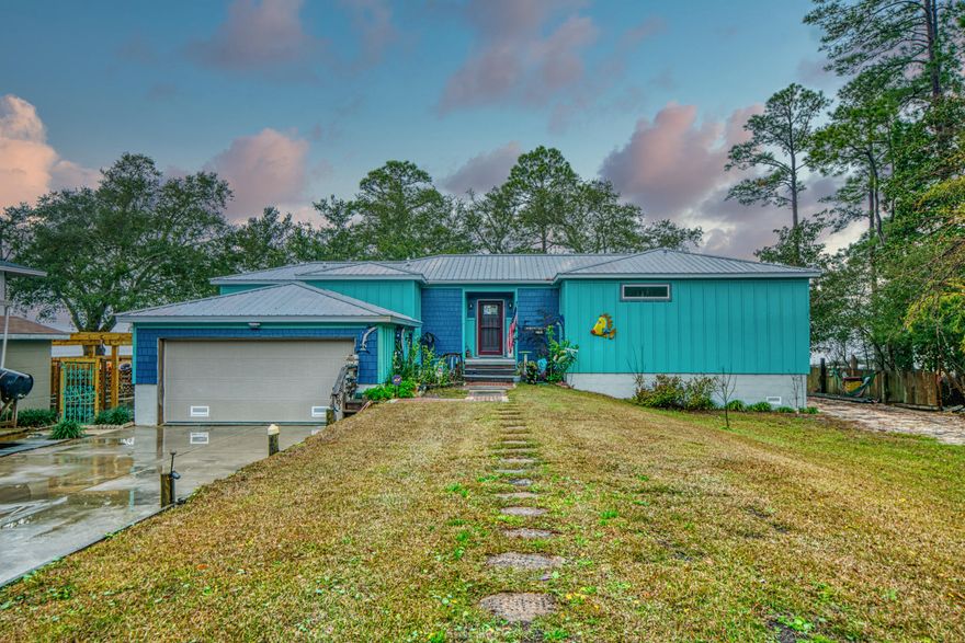 Beautiful custom built BAY FRONT home with metal roof, double car garage, hardie siding, low E windows. Built in 2016 to latest/new codes offering a workshop, green house, trellis over raised garden, fruit orchard, fabulous bay views with over 600 sq ft of outside trek decks, dock, covered boat lift, incredible sunsets. Spilt gas/electric hvac called hybrid, gas tankless water heater. This custom built home offers 9 ft ceilings, Brazilian Cherry hardwood floors thru out home with upgraded carpet in master bedroom and guest bedroom. Walk in master closet, dual sinks with walk in marble shower. The open kitchen features antique white glazed cabinets, glass uppers, gas stove, cabinet pantry plus additional sliding glass door pantry. Large lot with covered RV parking with attached work shop