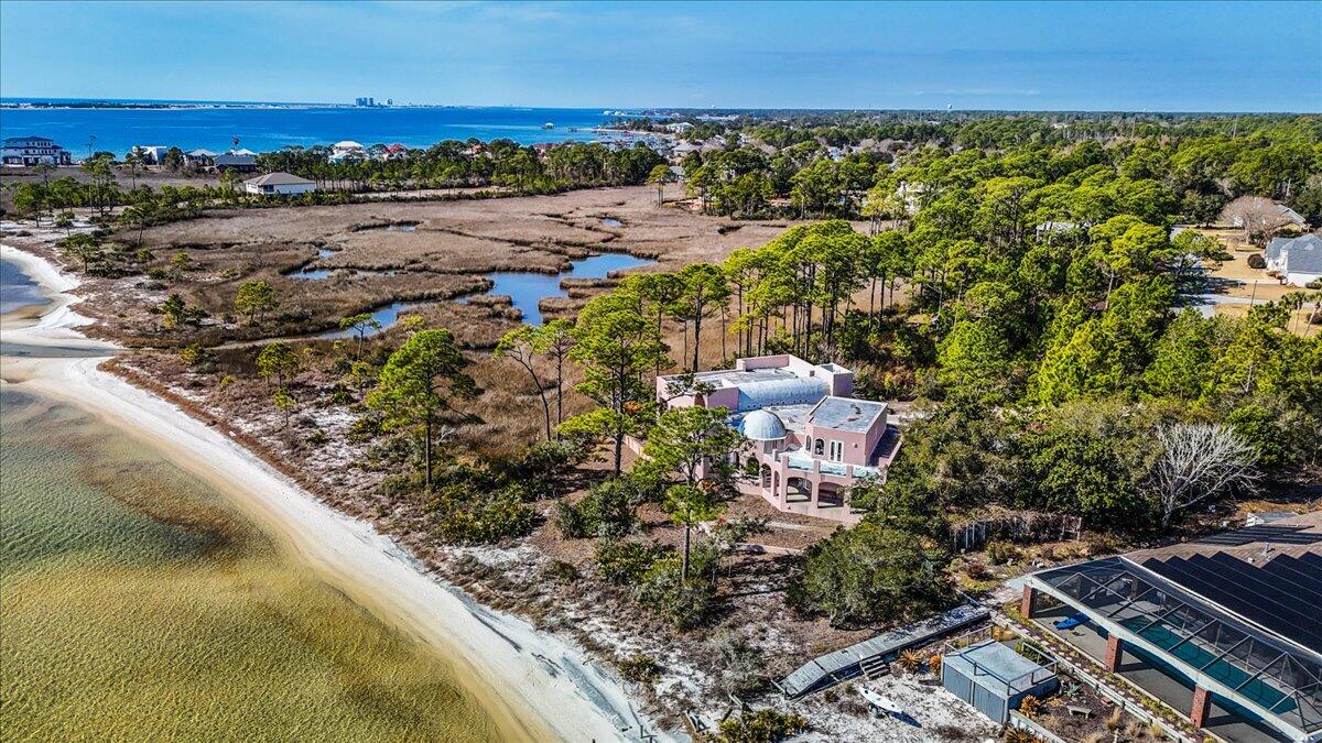Welcome to your dream waterfront estate! This custom Mediterranean-style home with durable ICF construction, offers unparalleled elegance and breathtaking views of the Santa Rosa Sound. Step inside to discover exquisite details at every turn. The home exudes elegance, featuring dramatic floor-to-ceiling columns, handcrafted doors and a spectacular Mahogany staircase that leads to 2 beautifully appointed rooms. Master suite is a haven of comfort & sophistication, with a cozy sitting area and pass-through gas fireplace that adds warmth & charm. Geothermal HVAC. Experience the serene beauty of 295' of private waterfront from your covered patio, complete with elegant cypress wood ceilings, offering the perfect place to relax and take in the breathtaking views. Schedule a private showing today