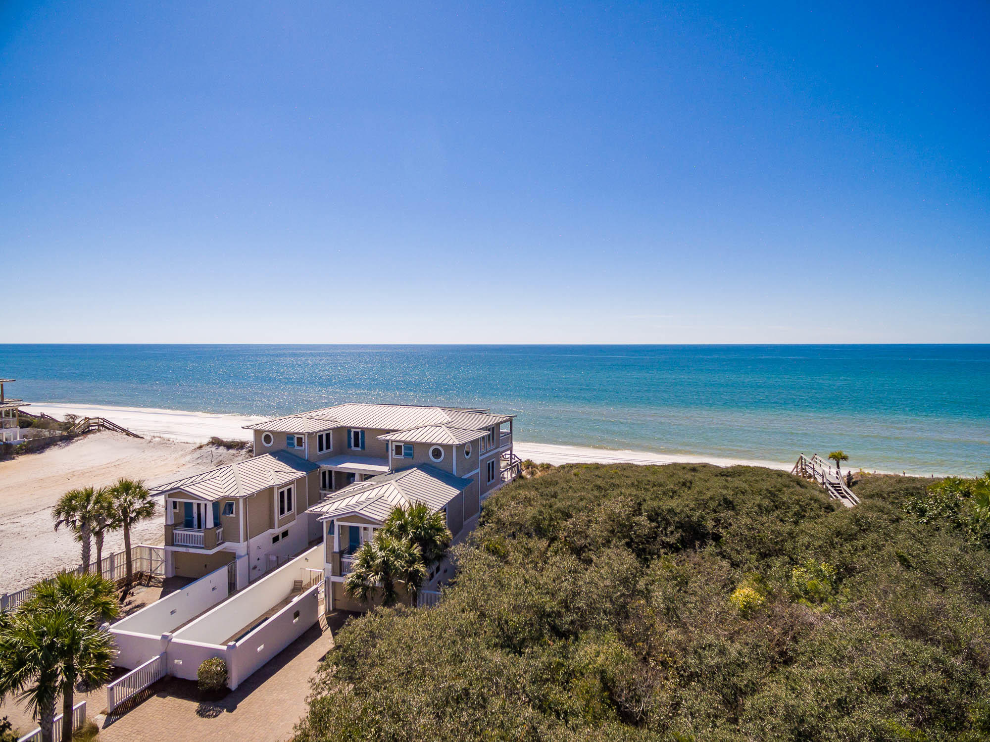 Prominently poised on 75 feet of Gulf-frontage on a private gated road, on the popular east end of the Scenic Highway 30A corridor is this exceptionally large Gulf-front beach house, ideal for quintessential beach gatherings. This exclusive investment property is one of the top-performing vacation rentals along our coast, with an impressive established annual rental income history of over $385,000 and trending to over $395K! The high elevation affords breathtaking panoramic Gulf views. Enjoy the luxury of walking directly from your deck onto the white sands via your private beach walkover, extending from the second level deck. The gated community boasts a prime location, just east of WaterSound Beach and just west of Alys Beach and Rosemary Beach. Offered fully furnished, this 10-bedroom