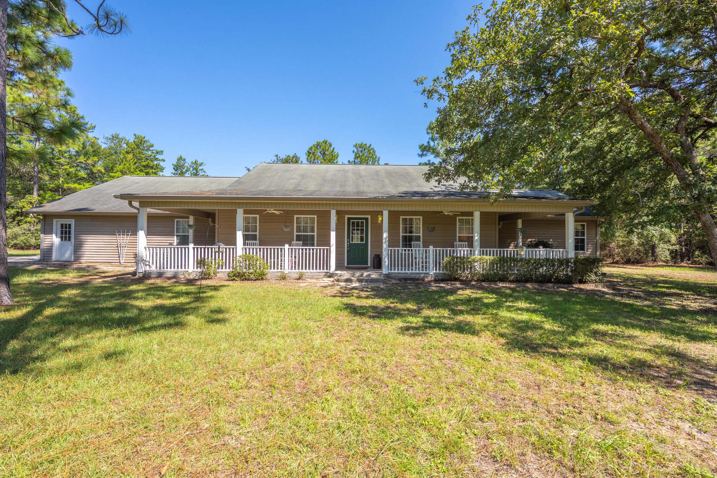 Spanning 10 acres, this estate offers a 4-bedroom, 4-bath main home (3 en-suites), a 2-bedroom, 2.5-bath guest house, an unfinished 3-room carriage house with 2 horse stalls, covered RV storage, and a mechanic's garage.The 2,988 sq ft main residence was designed for comfort and function with thermal pane windows, a wrap-around porch, screened back porch, and saltwater pool. Inside you'll find a formal dining room with wood trim, office, family room with fireplace, and an eat-in kitchen featuring hickory cabinets, double wall oven (2022), new microwave (2023), oversized Samsung refrigerator, pantry, and stone double sink. The master suite offers a walk-in closet, private garden porch, and spa bath with Jacuzzi tub, walk-in shower, dual vanities, and its own water heater. Additional bedrooms include two with private baths and a fourth with adjacent full bath.
The 1,275 sq ft guest house (2004) provides full independence with two bedrooms, 2.5 baths, full kitchen, living room, laundry, screened front porch, and 2-car garage. The 864 sq ft carriage house is insulated, wired, and partially finished with three rooms and two 12x12 stalls. Other amenities include a wired barn, 12x20 mechanic's garage, 12x36 RV shed, and two 350-ft deep wells with separate pump houses.
Updates and extras include wood trim accents, new paint on the carriage house and barn (2024), heavy-duty vinyl siding on both homes, new pool pump (2018), auto pool cleaner (2023), attic fan, serviced HVAC systems (2024), gutters, and termite contracts. Electrical panels on both homes are generator-ready, with multiple septic systems for efficiency. Cox Cable, Dish, and Hughes Network are ready to hook up.
This property combines modern updates with unmatched versatility for multi-generational living, equestrian pursuits, or anyone seeking a private, well-equipped estate.
