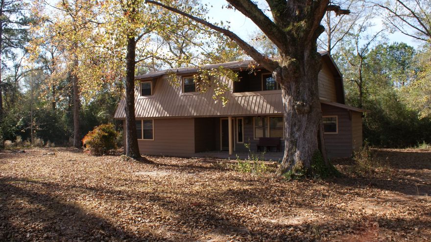 This home is an optional buy from the whole parcel listing of 22 acres with two homes and one mobile home. This home is approximately 2100 square feet. You have the option to add more land to this sale with a total of up to approximately 14 acres. This home will make you feel like you are on vacation all the time. Between the beautiful Oak trees and pecan trees surrounding the home, and not to mention the cabin feel that you will get when you walk through the front door. There is one bedroom and one bath downstairs. Upstairs has two large bedrooms with a full bath. The full bath has recently received an addition of a beautiful stand up tile shower. Please call today with any questions or to set up a showing.