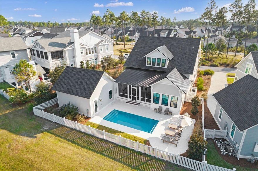 Located on one of the most coveted streets in Origins, this custom home by Arkon is within the exclusive WaterSound Origins community. Completed in 2021, this nearly-new beach home comes with its own heated saltwater pool, outdoor shower and sun deck on a picturesque and tranquil pond. The full-width front porch is a quiet shady spot for enjoying a book or socializing with family and friends at sunset. Inside, beautiful hardwood flooring and shiplap walls reflect the surrounding natural environment that Origins is known for. The bright and airy living room has ample space for entertaining. It flows naturally from the sitting area around the fireplace to the open dining area and kitchen.