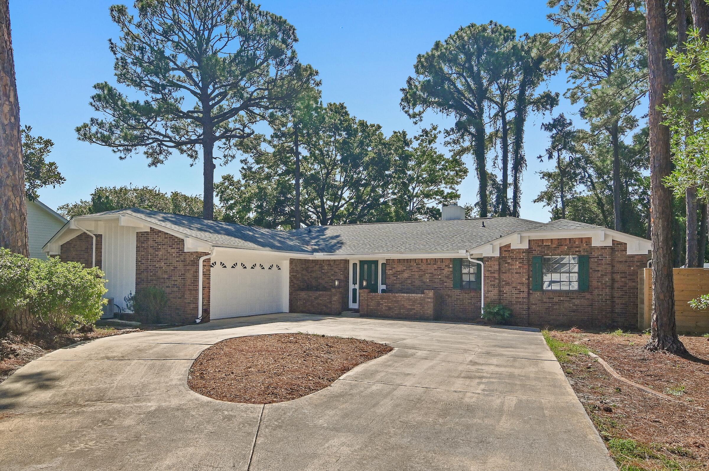 New roof located in the heart of Destin. Nestled in a quaint golf club community with easy access to the gulf, harbor, and World's Luckiest Fishing Village. This home is robust construction ideally situated between Choctawhatchee Bay and the Gulf of Mexico. This 2/2 home has had multiple upgrades in the past two years to include a new roof, fresh paint, lighting, skylights, multiple trees removed, a new fence, flooring throughout and popcorn ceilings removed. This floor plan creates a huge open floor concept living, cooking, and dining area with built-in bookshelves and fully functional fireplace for those chilly winter evenings. The rear patio provides a seamless transition for indoor/outdoor living. The garage floor has recently been resurfaced and the backyard has ample room for a pool and this home includes a generator.
