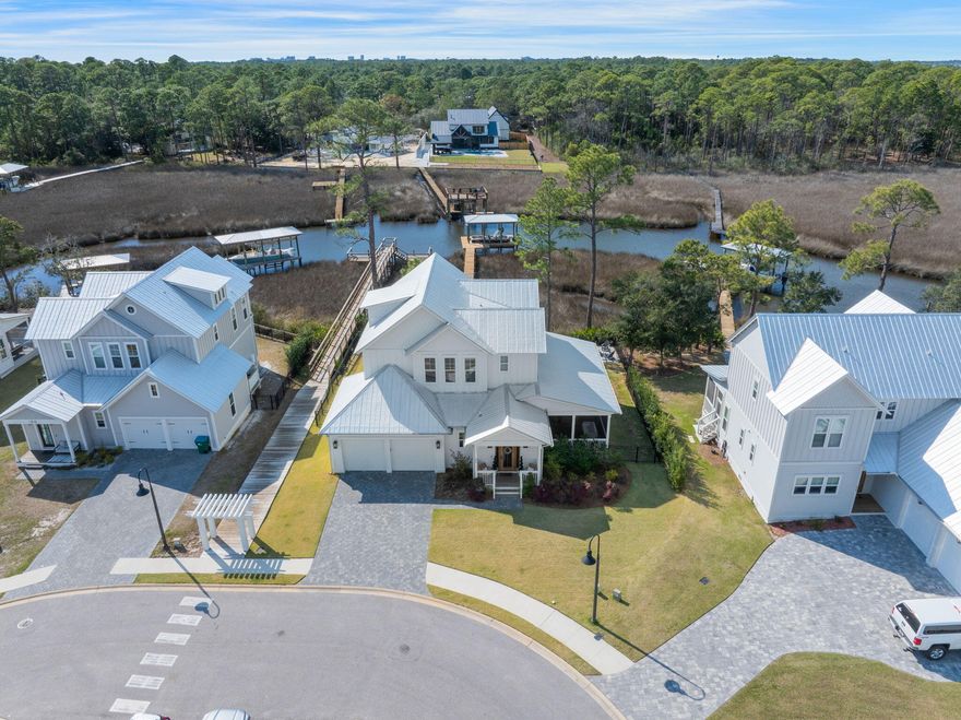 This stunning 4-bedroom, 3.5-bath home offers breathtaking bayou views. Located in a peaceful cul-de-sac, the open-concept living area features stylish decor and a well-appointed kitchen with stainless steel appliances, a zellige tile backsplash, and a Venetian plastered hood. The large screened-in porch offers space for gatherings with tranquil water views. The luxurious master suite includes a walk-in closet, soaking tub, and private porch. Enjoy a private boat dock, community pool, and close proximity to 30A beaches, shopping, and dining. Schedule a showing today! Buyer to verify all dimensions.
