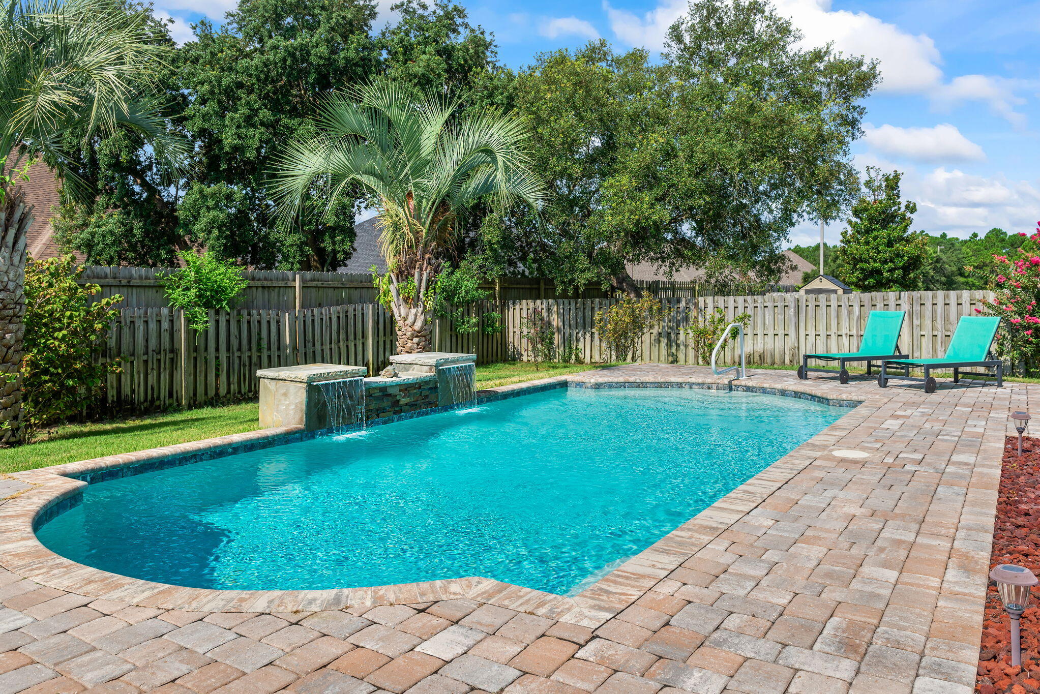Welcome to an Oasis Paradise with your Gorgeous Pool Home with fountain in Exclusive PUD neighborhood of Woodlawn Heights! Captivating Pool Home with Flowing Fountains & Upscale Finishes! Welcome to this gorgeous all-brick 4-bedroom, 2.5-bath pool home, offering luxurious indoor and outdoor living! The backyard is an entertainer's paradise, featuring a breathtaking gunite pool with flowing fountains, surrounded by elegant pavers and full fencing for privacy. Enjoy year-round views from your enclosed lanai, complete with storm windows that open from either side, perfect for morning coffee or evening gathering summer, fall, or winter. Inside, the home exudes style and sophistication with LVP flooring throughout, neutral soft grey palette, crown molding, and bullnose corners. The chef's kitc kitchen boasts granite countertops, soft honey brown cabinetry, stainless steel appliances, drop lighting, a large granite island with power, office desk nook, upgraded backsplash, and a spacious pantry. The formal dining room is a showstopper with inlet walls, chair rail, and custom windows, mirrored in the front bedroom's stunning architectural details. The living room is warm and inviting with built-in shelving, ceramic tile flooring, and a tiled fireplace. French doors lead you to the lanai from both the living room and the master suite. The master bedroom features a vaulted ceiling with crown molding, while the master bath is a true retreat complete with double vanities, beveled mirrors, jetted tub, tiled shower, tiled flooring, updated lighting, and dual closets. A Jack & Jill bath connects two additional bedrooms, offering functionality and privacy. Welcome home to Woodlawn Heights, one of Gulf Breeze's most sought-after neighborhoods for its lighted streets, underground utilities, sidewalks, ponds, playground, and even an RV/Boat storage area. This neighborhood is zoned for West Navarre Primary, Woodlawn Beach Middle, and Gulf Breeze High School, all excellently rated schools. As you enter this beautiful 2541 sq. ft. home featuring 4 bedrooms and 2.5 baths you will be drawn to the upgrades immediately. Lighted streets, underground utilities, sidewalks, ponds, playground; From the dining area with chair rail and decorative arches just off the foyer to the dramatic cathedral ceilings in the great room and trey ceilings in the master bedroom, this 'Designer Series' Gooden Home has so many wonderful features. Don't miss the bull nose corners and plant ledges throughout. This home is impeccably maintained and truly move-in ready every detail thoughtfully designed for comfort, beauty, and easy entertaining. Don't miss your chance to own this resort-style gem!