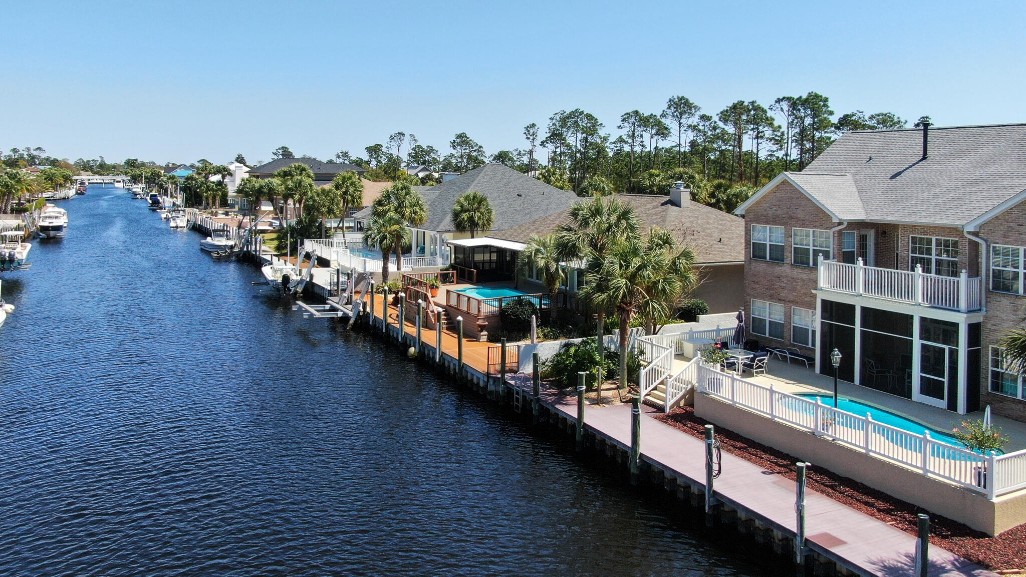 Exquisite Georgian style home on the canal in prestigious Bay Point.  This house is the perfect combination of charm with a floor plan that is sure to impress.   Gorgeous views of the canal and lots of light give an open airy feel.  Entering you'll notice the high ceilings, a library and formal dining room.  Spacious kitchen features ample, custom-built cabinets,  double ovens, island with electric stove and drybar.   Just off the kitchen is a wet-bar with icemaker and custom cabinetry.  First floor master bedroom offers views of the canal. Large bathroom with walk-in closet.  Flooring consists of hardwood, tile and carpet.   2nd Floor features an open bonus/media room/den/playroom with surround sound and 3 additional bedrooms. Back downstairs head out to your screened porch, take a dip in