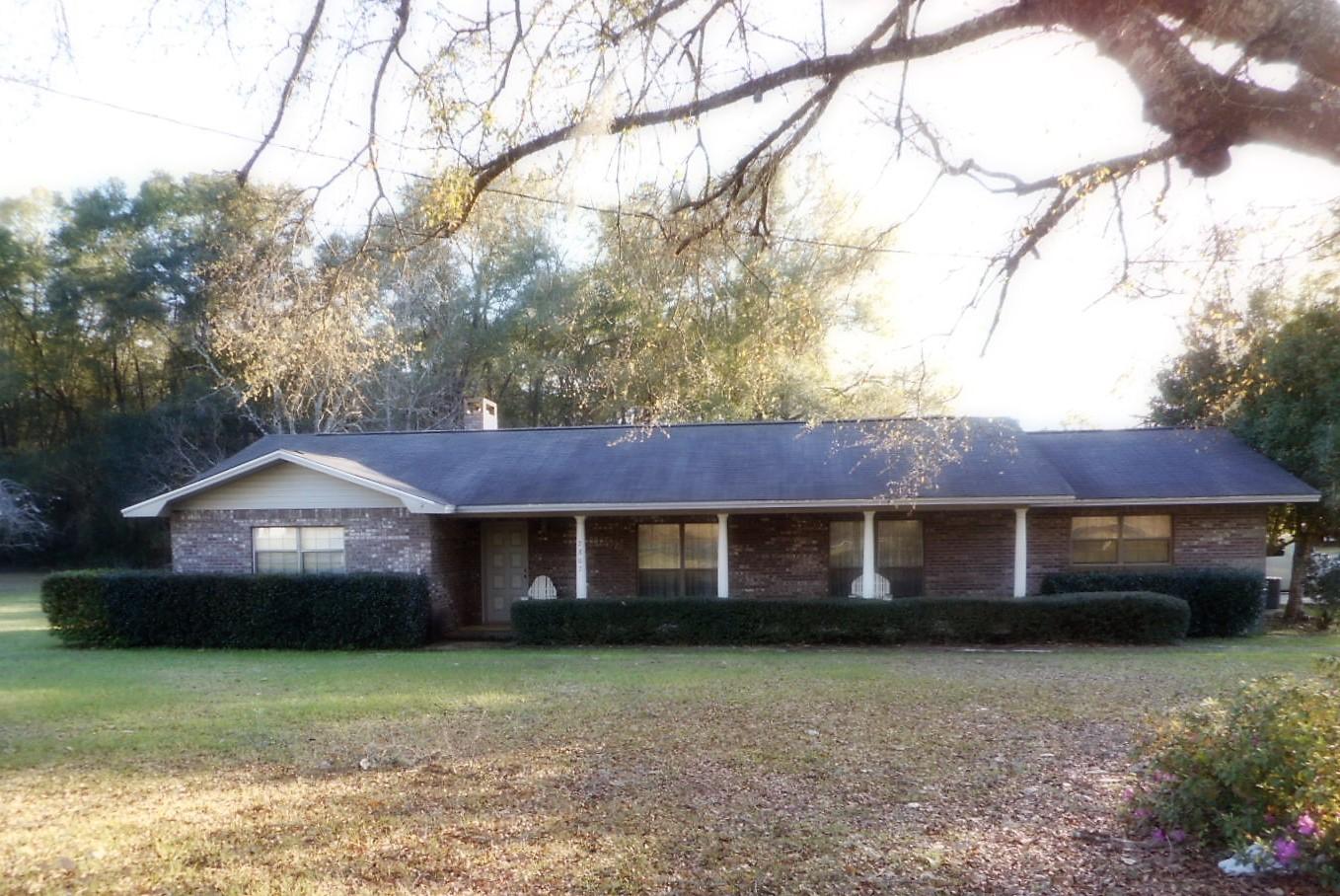 This 2057 SF, masonry home has so much to offer. Not only does it have spacious main residence. It also has a second dwelling on the property previously used as business. It could be mother-in-law quarters or guest house. This second dwelling is 3/2, 1144 SF with 2007 HVAC, and was renovated in 2003. Primary home has a detached 19 x 24 workshop with electric and work bench. Workshop is wired for a generator to run the home in case of emergency. City water and sewer to both homes. All appliances stay with both homes. Primary home has large bedrooms with king size beds in each one. Master bedroom has handicap accessible bath. Split bedroom floor plan. Vaulted ceiling and fireplace in den, formal DR & LR. Two car carport and concrete drive. Paved road frontage. Fruit trees include pear,