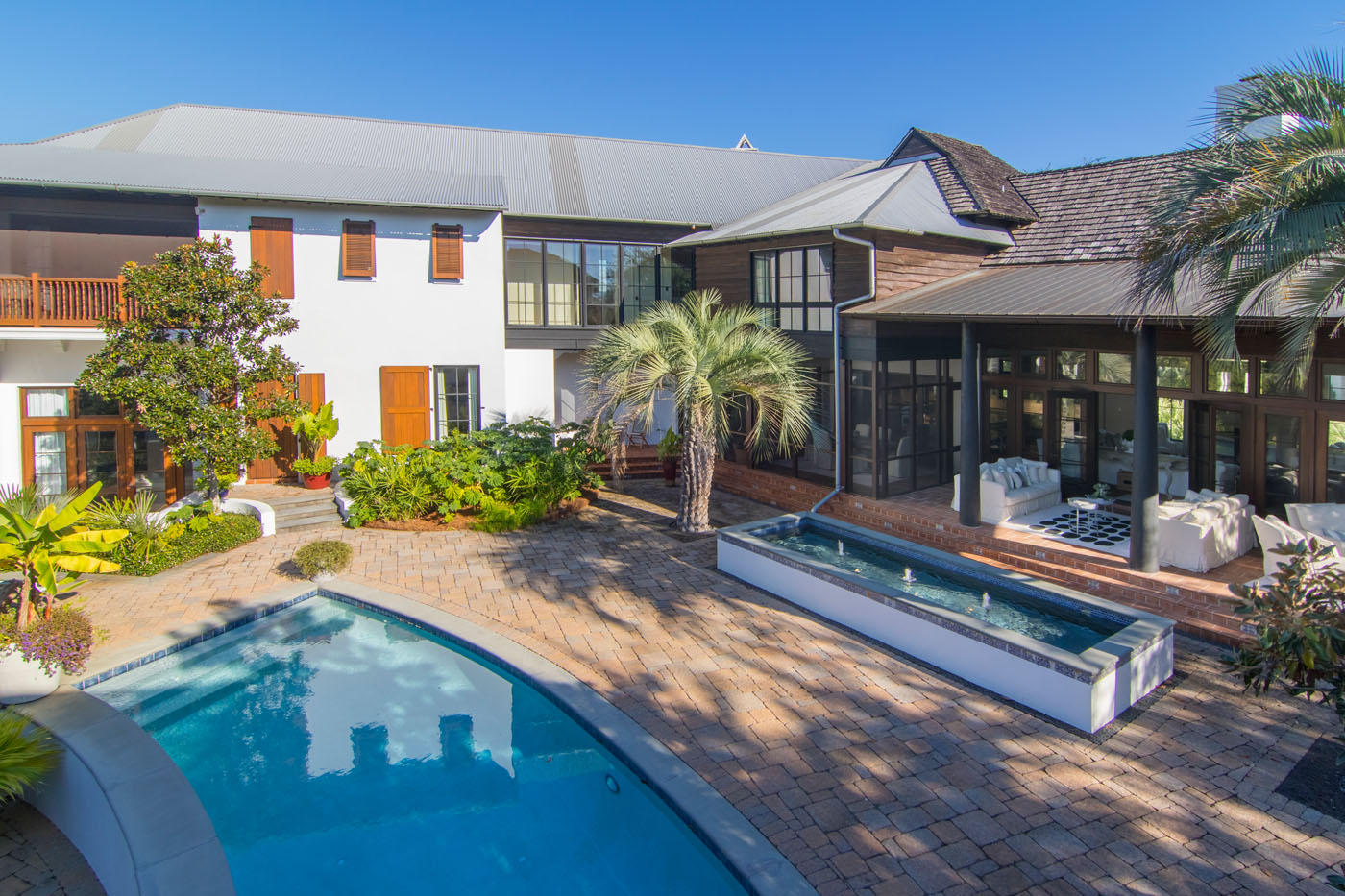 Sitting on the largest lot in Rosemary Beach, this grand custom villa is like no other in the community. Designed by Darrell Russell, principal architect at A Boheme Design, this property exhibits a Mediterranean inspired design with hints of Old Havana. With more than 6,000 square feet of custom indoor and covered outdoor space, this home was built for full-time livability that comes with large rooms, custom finishes and ample storage and closet space. Indoors, the expansive living/dining room and kitchen features newly painted walls, new cabinetry and marble counters, oversized island, vaulted wood ceiling and stone floors. The custom kitchen includes custom cabinets, Sub-Zero refrigerator, wine cooler and ice maker, Wolf range and double oven, and two Fisher & Paykel dishwasher drawers.