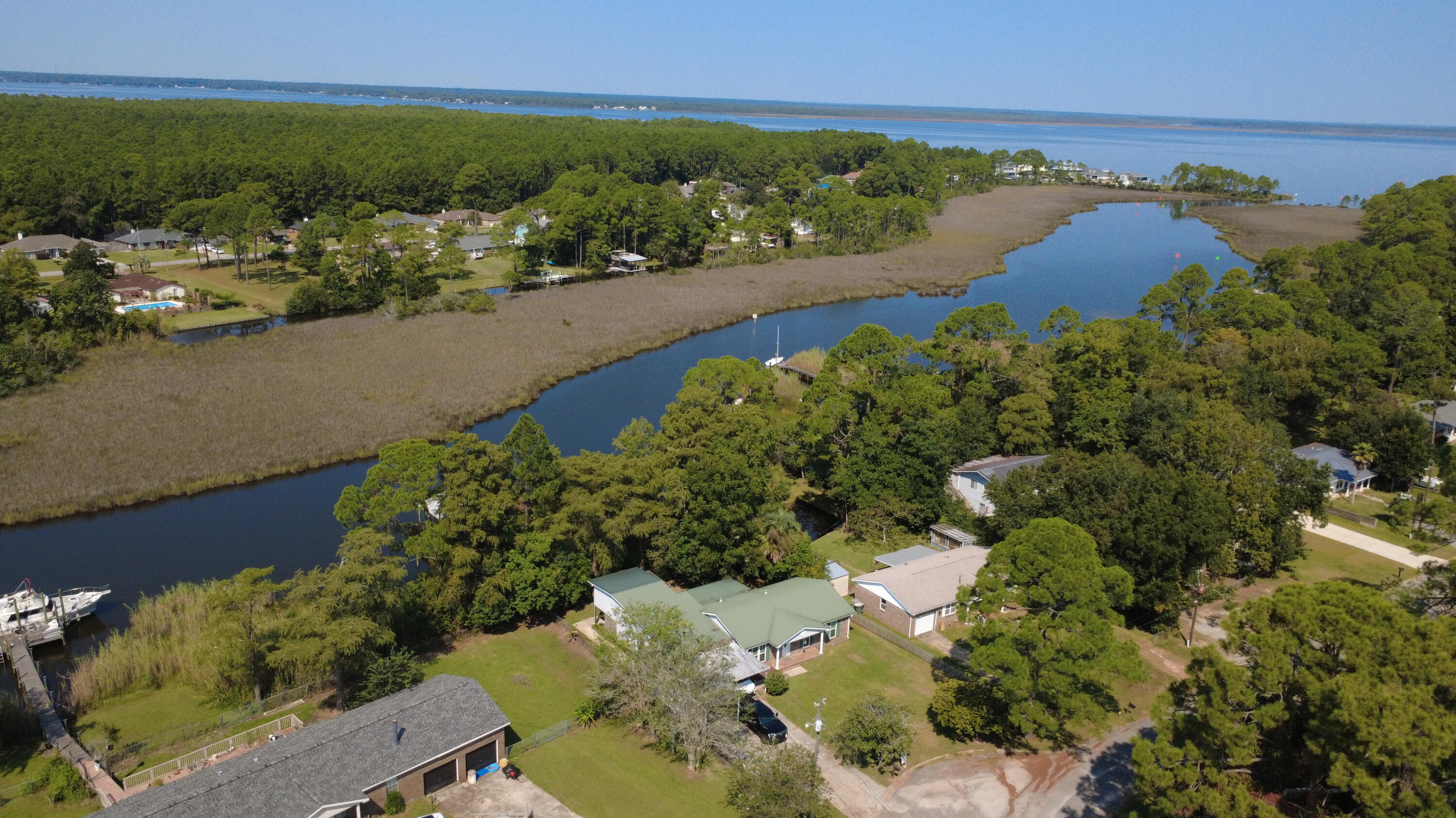 WATERFRONT PARADISE - this property has it all! Located on a DEEPWATER BAYOU with direct access to Perdido BAY and the GULF past that, this home offers a LARGE DOCK with a BOAT LIFT and views of the water from throughout the home! The spacious house features UPDATES throughout, a HUGE SUNROOM overlooking the water, an abundance of parking, and an updated, detached IN-LAW SUITE overlooking the bayou! The layout provides privacy to the bedrooms on one side of the house and the open concept living area on the opposite end. Out back the waterfront in-law suite is fully independent, with its own kitchenette, bathroom, and laundry. The garage is oversized with room for a workshop, 2 cars, and storage. Additional parking out front can accommodate an RV/boat and 4 cars under 2 carports, and an additional 2-3 cars uncovered in the driveway! This home has it all, so make your waterfront dream come true!
