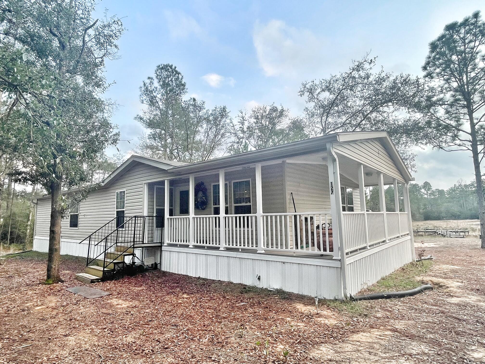 This home is practically brand new! It was built in 2020 and the sellers have only lived in it for 6 months. It's located on a little over 1 acre. This home is located on a waterfront lot but the dam was damaged and the lake emptied. The lake is beginning to refill with water and per the seller's the state is working to repair the dam. (not sure timeframe) Very quiet area close to shopping, and just 40 minutes to the beaches of South Walton. This home has a wrap around porch, large living area with sliding doors that overlook the back yard, spacious kitchen with tons of cabinets, large master bedroom with walk-in closet, master bath with double vanity and walk-in shower, extra built-in storage cabinets. All measurements must be verified by buyer. Schedule your tour today!