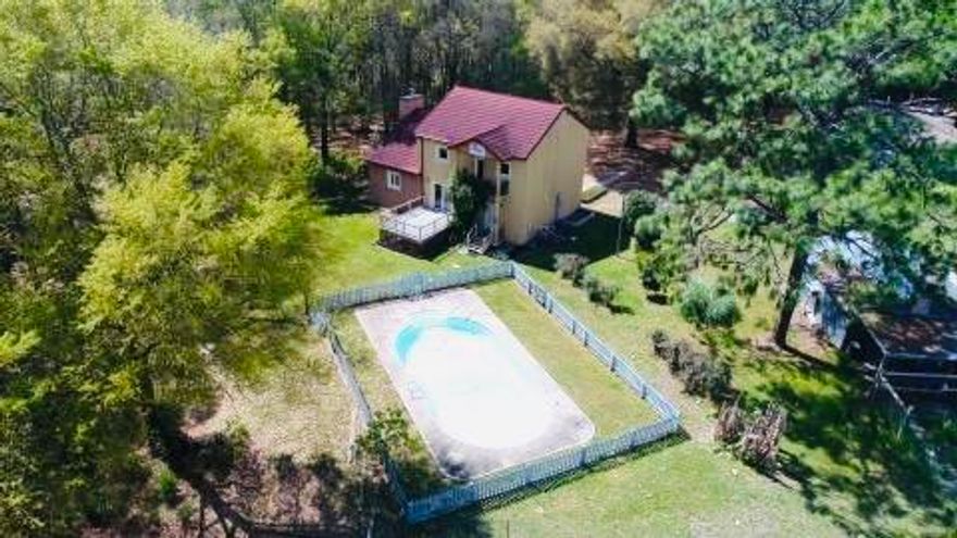 Beautiful and private 4.73 acres of land with 2 homes, horse barn with 5 stalls, 2 stalls inside and 3 outside, a 200x60 riding arena, spacious workshop plus an in-ground pool. You will find lots of mature trees throughout. The home located on the left is a ranch style home and offers 3 bedrooms, 2 full baths, built in 1965 with 1232 square feet. This home has been remodeled with new laminate flooring, carpets and painted inside and out. The second home built in 2008 is a Mediterranean style home with ICF construction. It has 2 bedrooms, 2 1/2 baths with 2100 square feet and an in-ground pool out back. It is a split level home with multiple balconies with great views plus built in shutters on every window for extra privacy. It's rated for 220 mph sustained winds with shutters down