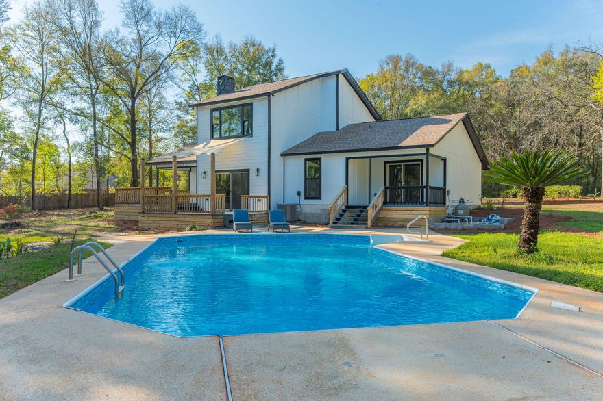 Welcome to your private estate in Crestview-nestled on 2 acres and set back nearly a quarter mile for ultimate privacy. Completely rebuilt from the ground up in 2023, everything is brand new as of 2023: 2023 windows, 2023 doors, 2023 Hardie board siding, 2023 roof, 2023 plumbing, 2023 electrical, 2023 insulation, 2023 HVAC systems, 2023 pool liner, kitchen, appliances, and bathrooms--even utility connections. Enjoy a large swimming pool, 550+ sq ft of decking, and a paved circular driveway with room for a future six-car garage. Inside features coastal-inspired design with shiplap, quartz countertops, tiled walk-in showers, designer fixtures, and light sandy oak LVP flooring. Fully permitted 2023 rebuild. This is essentially a new construction home with the charm of an established setting.