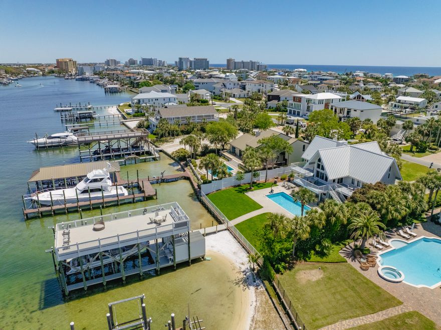 EXTRAORDINARY, DEEP-WATER, YACHTSMAN'S & SPORTSFISHERMAN'S WATER-FRONT ESTATE oriented on Destin, Florida's Scenic Harbor.  Located within the legendary enclave of Holiday Isle, this exclusive address is the only harbor-front estate currently offered for sale and rarely do like-kind opportunities arise on the South side of the gorgeous Harbor due to such a limited density of lots fronting the harbor. Holiday Isle is unique in that it offers dedicated beach access for its ownership and their guests, which is afforded through very reasonable dues, currently $495.00/annually.  An estate of this caliber and distinction should be viewed as a generational ownership opportunity, as the phenomenal lifestyle it offers is unrivaled anywhere along the Emerald Coast on the... on the Gulf of America.  This property has been beautifully renovated and newly decorated and is being offered turnkey; fully furnished and accessorized with all audio and video.  The dock structure and its features are irreplaceable; "grandfathered" specifications, thus providing an instant solution to moor and lift your boats, yachts, skid for jet skis, paddleboards, tackle/storage room, motorized catch lift and guided aluminum rails to the fish cleaning station, and a magnificent rooftop sunbathing  and stargazing terrace atop two of the covered slips; all accessible directly from your private backyard, which includes an expansive heated pool.  The hardscaping, landscaping, and ambient exterior and dock lighting accentuate the distinctive roof and dock elevations. Quite a scope of improvements have recently been completed, including but not limited to the following: (2) natural gas Rinnai tankless hot water heaters that supply the entire house; all recessed lights throughout were replaced with efficient LED technology; entire interior repainted including all new moldings; exterior deck painted and sealed; all exterior railings painted; new insulated, modernized garage doors and openers; AquaLink technology that allows for control of the pool functions via smartphone app; Control 4 home automation app also interfaces with the TV's.  (2) new Trane A/C units installed; while all four units have new Trane thermostats controlled remotely via app; oversized double floating jet dock installed; (7) high resolution digital home surveillance cameras with cloud-based NVR; (4) boat dock Luma surveillance cameras.  Wi-Fi module added to the Generac whole house generator allowing for interface with a smartphone app as well. The most extraordinary dock, slips, boathouse, and boathouse rooftop terrace on Holiday Isle with spectacular view corridor of the scenic harbor and fabulous sunsets.  Please inquire for further details and to schedule a private showing.