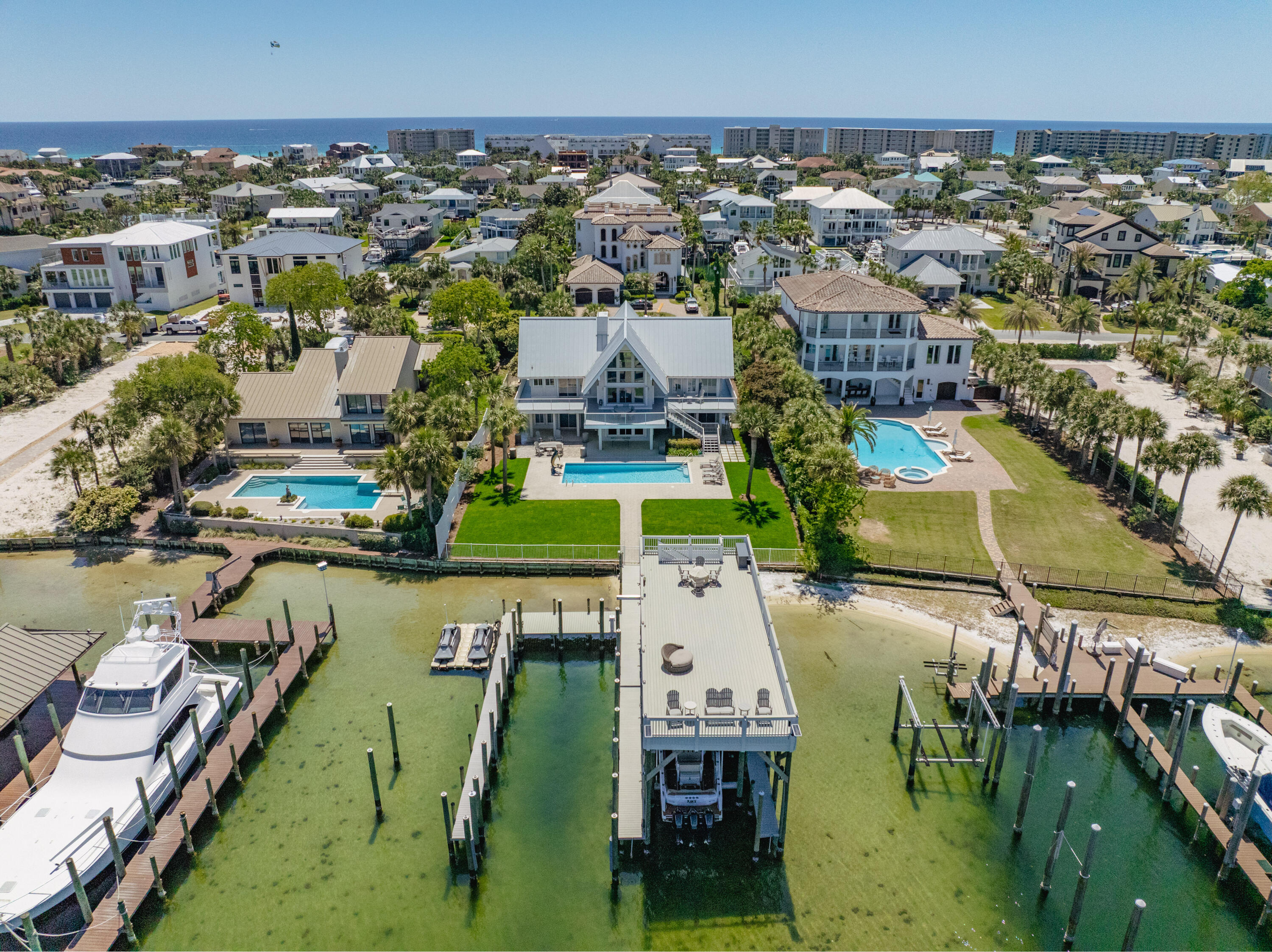 EXTRAORDINARY, DEEP-WATER, YACHTSMAN'S & SPORTSFISHERMAN'S WATER-FRONT ESTATE oriented on Destin, Florida's Scenic Harbor.  Located within the legendary enclave of Holiday Isle, this exclusive address is the only harbor-front estate currently offered for sale and rarely do like-kind opportunities arise on the South side of the gorgeous Harbor due to such a limited density of lots fronting the harbor. Holiday Isle is unique in that it offers dedicated beach access for its ownership and their guests, which is afforded through very reasonable dues, currently $495.00/annually.  An estate of this caliber and distinction should be viewed as a generational ownership opportunity, as the phenomenal lifestyle it offers is unrivaled anywhere along the Emerald Coast on the... on the Gulf of America.  This property has been beautifully renovated and newly decorated and is being offered turnkey; fully furnished and accessorized with all audio and video.  The dock structure and its features are irreplaceable; "grandfathered" specifications, thus providing an instant solution to moor and lift your boats, yachts, skid for jet skis, paddleboards, tackle/storage room, motorized catch lift and guided aluminum rails to the fish cleaning station, and a magnificent rooftop sunbathing  and stargazing terrace atop two of the covered slips; all accessible directly from your private backyard, which includes an expansive heated pool.  The hardscaping, landscaping, and ambient exterior and dock lighting accentuate the distinctive roof and dock elevations. Quite a scope of improvements have recently been completed, including but not limited to the following: (2) natural gas Rinnai tankless hot water heaters that supply the entire house; all recessed lights throughout were replaced with efficient LED technology; entire interior repainted including all new moldings; exterior deck painted and sealed; all exterior railings painted; new insulated, modernized garage doors and openers; AquaLink technology that allows for control of the pool functions via smartphone app; Control 4 home automation app also interfaces with the TV's.  (2) new Trane A/C units installed; while all four units have new Trane thermostats controlled remotely via app; oversized double floating jet dock installed; (7) high resolution digital home surveillance cameras with cloud-based NVR; (4) boat dock Luma surveillance cameras.  Wi-Fi module added to the Generac whole house generator allowing for interface with a smartphone app as well. The most extraordinary dock, slips, boathouse, and boathouse rooftop terrace on Holiday Isle with spectacular view corridor of the scenic harbor and fabulous sunsets.  Please inquire for further details and to schedule a private showing.