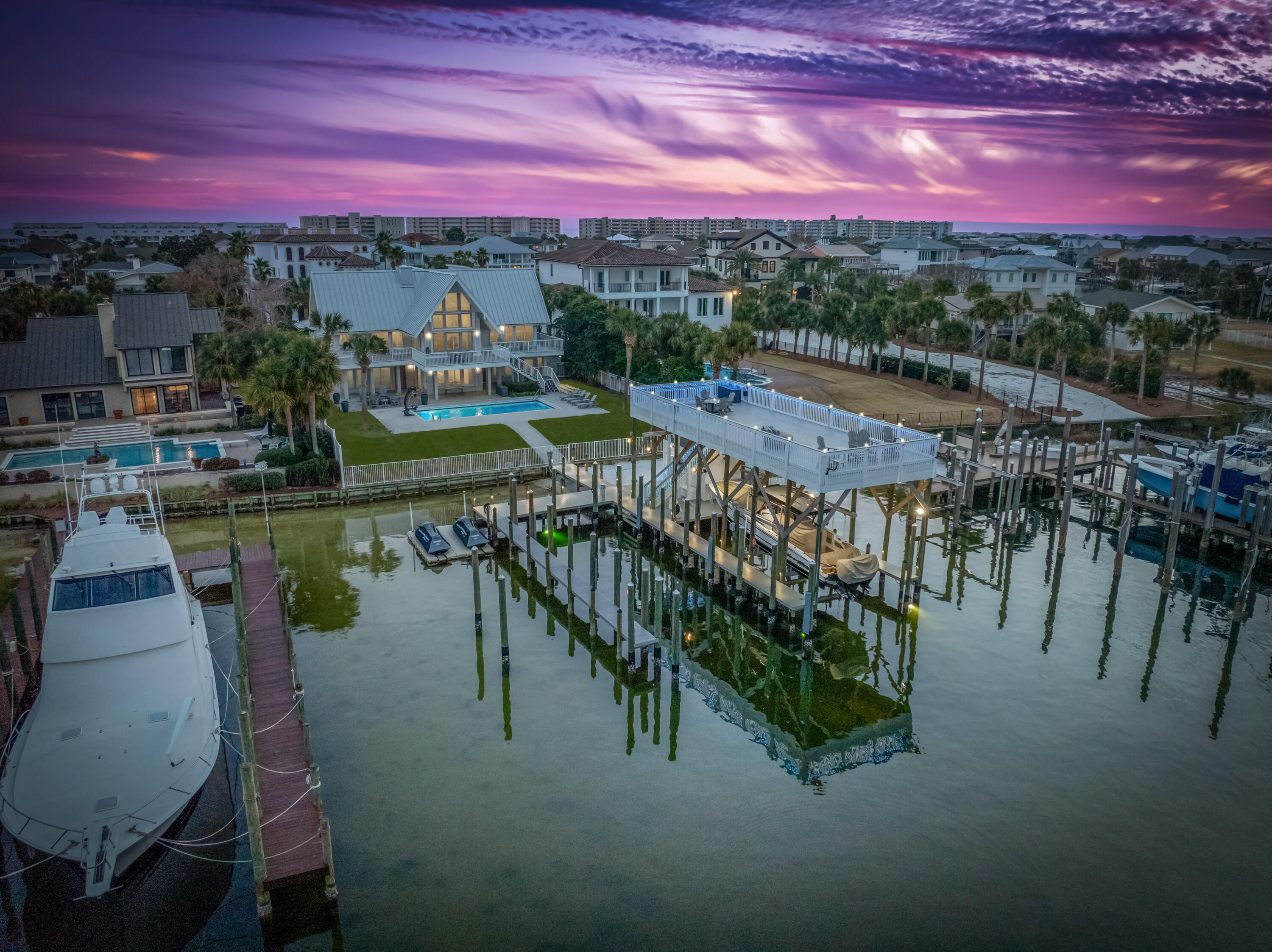 EXTRAORDINARY, DEEP-WATER, YACHTSMAN'S & SPORTSFISHERMAN'S WATER-FRONT ESTATE oriented on Destin, Florida's Scenic Harbor.  Located within the legendary enclave of Holiday Isle, this exclusive address is the only harbor-front estate currently offered for sale and rarely do like-kind opportunities arise on the South side of the gorgeous Harbor due to such a limited density of lots fronting the harbor. Holiday Isle is unique in that it offers dedicated beach access for its ownership and their guests, which is afforded through very reasonable dues, currently $495.00/annually.  An estate of this caliber and distinction should be viewed as a generational ownership opportunity, as the phenomenal lifestyle it offers is unrivaled anywhere along the Emerald Coast on the... on the Gulf of America.  This property has been beautifully renovated and newly decorated and is being offered turnkey; fully furnished and accessorized with all audio and video.  The dock structure and its features are irreplaceable; "grandfathered" specifications, thus providing an instant solution to moor and lift your boats, yachts, skid for jet skis, paddleboards, tackle/storage room, motorized catch lift and guided aluminum rails to the fish cleaning station, and a magnificent rooftop sunbathing  and stargazing terrace atop two of the covered slips; all accessible directly from your private backyard, which includes an expansive heated pool.  The hardscaping, landscaping, and ambient exterior and dock lighting accentuate the distinctive roof and dock elevations. Quite a scope of improvements have recently been completed, including but not limited to the following: (2) natural gas Rinnai tankless hot water heaters that supply the entire house; all recessed lights throughout were replaced with efficient LED technology; entire interior repainted including all new moldings; exterior deck painted and sealed; all exterior railings painted; new insulated, modernized garage doors and openers; AquaLink technology that allows for control of the pool functions via smartphone app; Control 4 home automation app also interfaces with the TV's.  (2) new Trane A/C units installed; while all four units have new Trane thermostats controlled remotely via app; oversized double floating jet dock installed; (7) high resolution digital home surveillance cameras with cloud-based NVR; (4) boat dock Luma surveillance cameras.  Wi-Fi module added to the Generac whole house generator allowing for interface with a smartphone app as well. The most extraordinary dock, slips, boathouse, and boathouse rooftop terrace on Holiday Isle with spectacular view corridor of the scenic harbor and fabulous sunsets.  Please inquire for further details and to schedule a private showing.