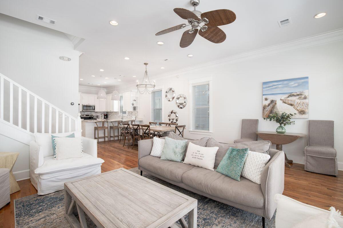 Freshly painted outside and tastefully updated within, this desirable beach home is well located between Alys and Rosemary Beach shops and eateries. Ideal as a primary or vacation property, this spacious coastal home is move in ready with four bedrooms plus bunks and three-and-a-half baths. Steps lead up to the traditional front porch, which provides a shady space for relaxation. Hardwood flooring greets you at the entrance. The sizeable living space is anchored by a feature fireplace, shiplap walls, soaring 10-ft. ceilings and elegant crown molding. There are windows on each side of the front door and a transom window above, casting ample natural daylight into this newly furnished space.