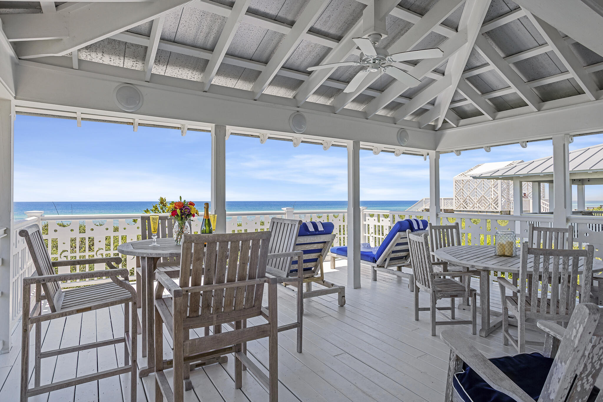 Proudly positioned Gulf front, is this lovely shingle-style Craftsman cottage designed by Richard Gibbs, who once served as Seaside's Town Architect. This charming beauty rises two stories above the snow-white dunes and is snuggled by care-free native oaks. The tabby chimney with exposed oyster shells is a unique feature of this Seaside cottage. An outdoor shower with rain-style shower head and accompanying storage room for beach toys are conveniently located adjacent to the entryway. Upon entry, three bedrooms- each with ensuite baths, are located on the first level. The charming master suite offers a cozy fireplace for chilly nights, and an adjoining 20' x 20' screened porch for those quiet times with either a good book or to sneak in a quick nap.  The baths were designed with playful