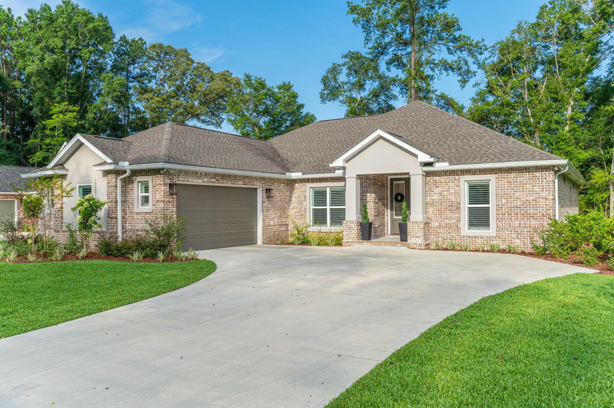 This 5/3 beauty is nestled in a gated community that offers peace of mind and curb appeal. Step inside and you'll be greeted by an open-concept living room and kitchen. The living room, with ceilings soaring up to 12 feet, features a cozy fireplace while the heart of the home, the chef-inspired kitchen, boasts upgraded stainless steel appliances, quartz countertops, a large island, and a breakfast nook. Throughout the home are plantation shutters, located in the front, and Roman shades in the rear of the home which add timeless elegance and privacy. The primary suite is a retreat with a beamed ceiling, wooden accent wall, and a spa-like en-suite bathroom complete with a soaker tub, double vanity, stand-up shower, and generous walk-in closet. Each of the additional bedrooms is spacious. Outside, the vibe is just as inviting. Unwind on the covered screened-in porch with a tongue-and-groove ceiling, or soak up the sun on the additional outdoor patio space, perfect for grilling or gathering.