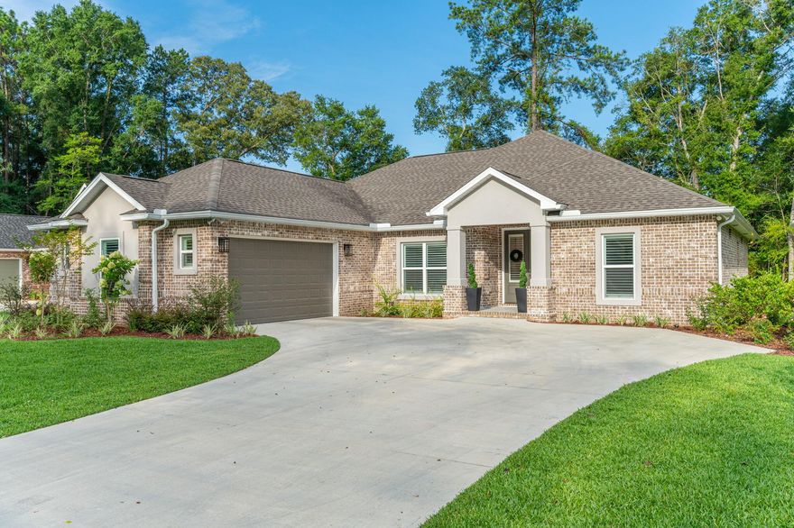 This 5/3 beauty is nestled in a gated community that offers peace of mind and curb appeal. Step inside and you'll be greeted by an open-concept living room and kitchen. The living room, with ceilings soaring up to 12 feet, features a cozy fireplace while the heart of the home, the chef-inspired kitchen, boasts upgraded stainless steel appliances, quartz countertops, a large island, and a breakfast nook. Throughout the home are plantation shutters, located in the front, and Roman shades in the rear of the home which add timeless elegance and privacy. The primary suite is a retreat with a beamed ceiling, wooden accent wall, and a spa-like en-suite bathroom complete with a soaker tub, double vanity, stand-up shower, and generous walk-in closet. Each of the additional bedrooms is spacious. Outside, the vibe is just as inviting. Unwind on the covered screened-in porch with a tongue-and-groove ceiling, or soak up the sun on the additional outdoor patio space, perfect for grilling or gathering. 