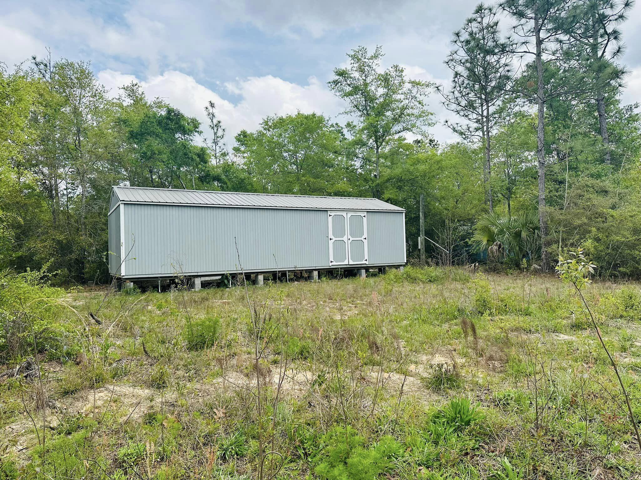 Welcome to this charming property sitting on a spacious third of an acre lot, offering ample space for outdoor activities and potential expansion. The highlight of this property is the impressive 14x60 Graceland shed, providing versatile storage or workshop space to suit your needs. Imagine the possibilities for hobbies, storage, or even a cozy retreat in this well-maintained shed. The expansive yard offers room for gardening, outdoor gatherings, or simply enjoying the peaceful surroundings. Don't miss out on this unique opportunity to own a property with such versatile potential. The property does not have utilities installed. While public water is available, the tap fee has not been paid. There is a power pole on the property, but it has not been permitted or connected.
