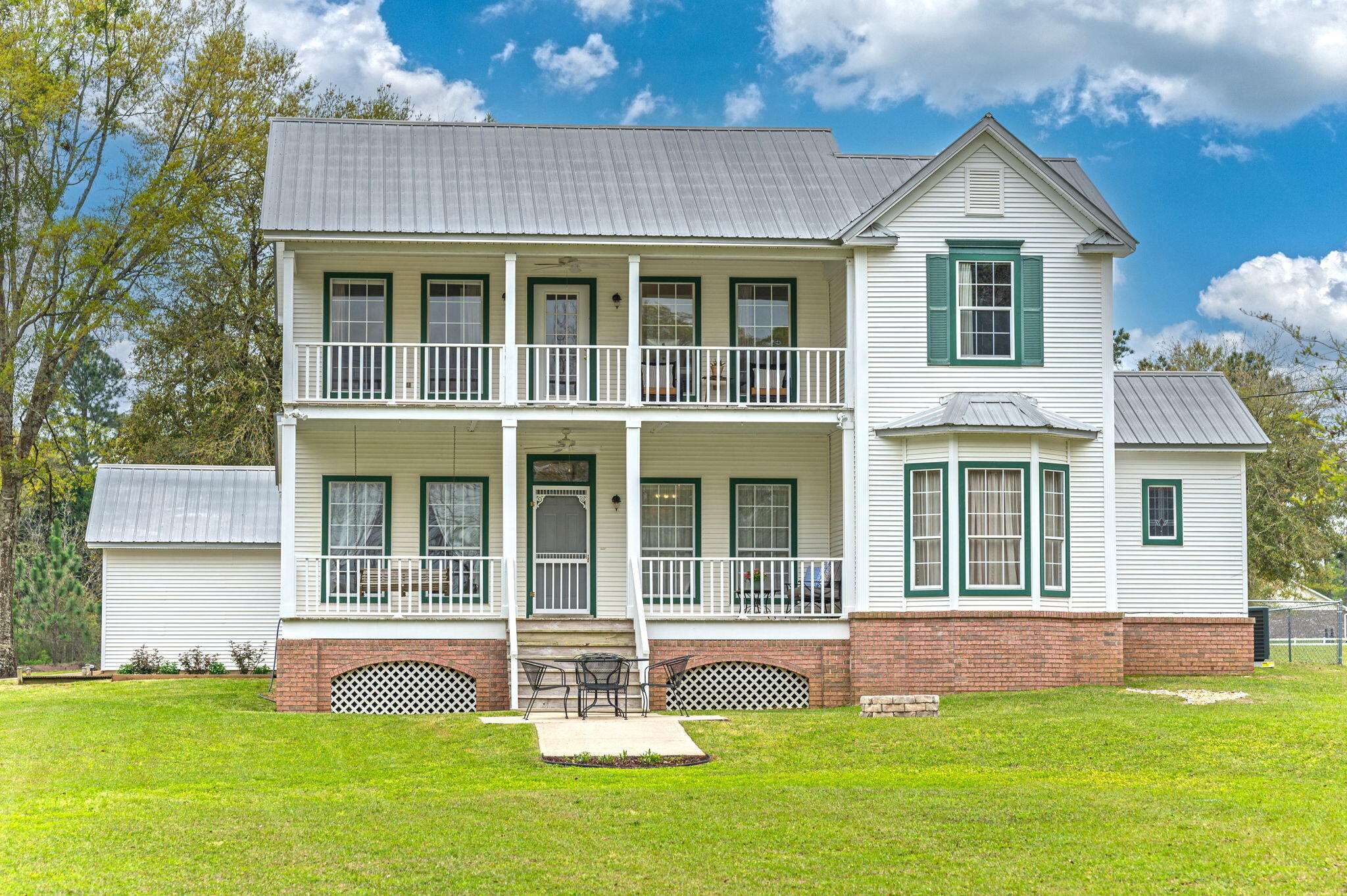 72 hour kick-out clause in place. Introducing a quintessential Southern Farmhouse exuding charm and tranquility, this property offers an idyllic retreat for those seeking peaceful country living. Nestled on 5 acres, the farmhouse's plans were designed by the owner's brother, an accomplished published architectural designer. Step inside to discover the timeless elegance of 2-inch tongue and groove oak slat flooring, complemented by three stained glass windows (repurposed from a church in England) found throughout the home. The heart of the home boasts a kitchen adorned with quartz countertops, lantern tile backsplash, and custom oak cabinets crafted by the owner's father.