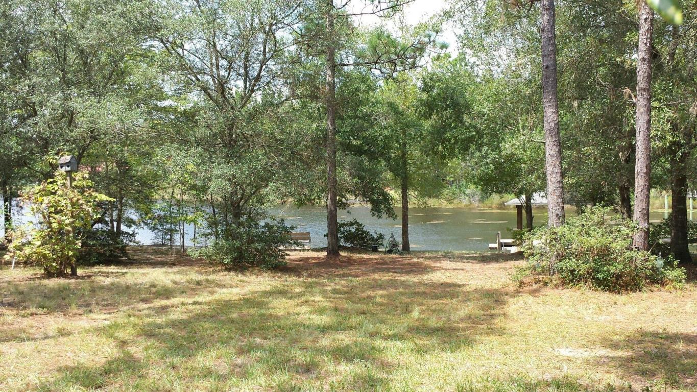 This beautiful lakefront property is one you have to see to believe! Almost 2.5 acres of land with 164 feet on the water complete with a covered 10x8 hip roof dock that leads out to a T-dock with side steps that allow for easy access into and out of your boat. Power has been run to at least the outhouse but the pipe is there for you to run power on down to the dock. Water also runs down to the dock and a phone line hookup is located on the front of the shed. There is an ''outhouse'' on the property complete with a toilet, sink, and shower so feel free to park your RV here for a while and relax and fish! There is also a small shed for storage on the property. A chain linked fence runs along the perimeter of the property (all 3 sides except at the water) down to within approximately 50