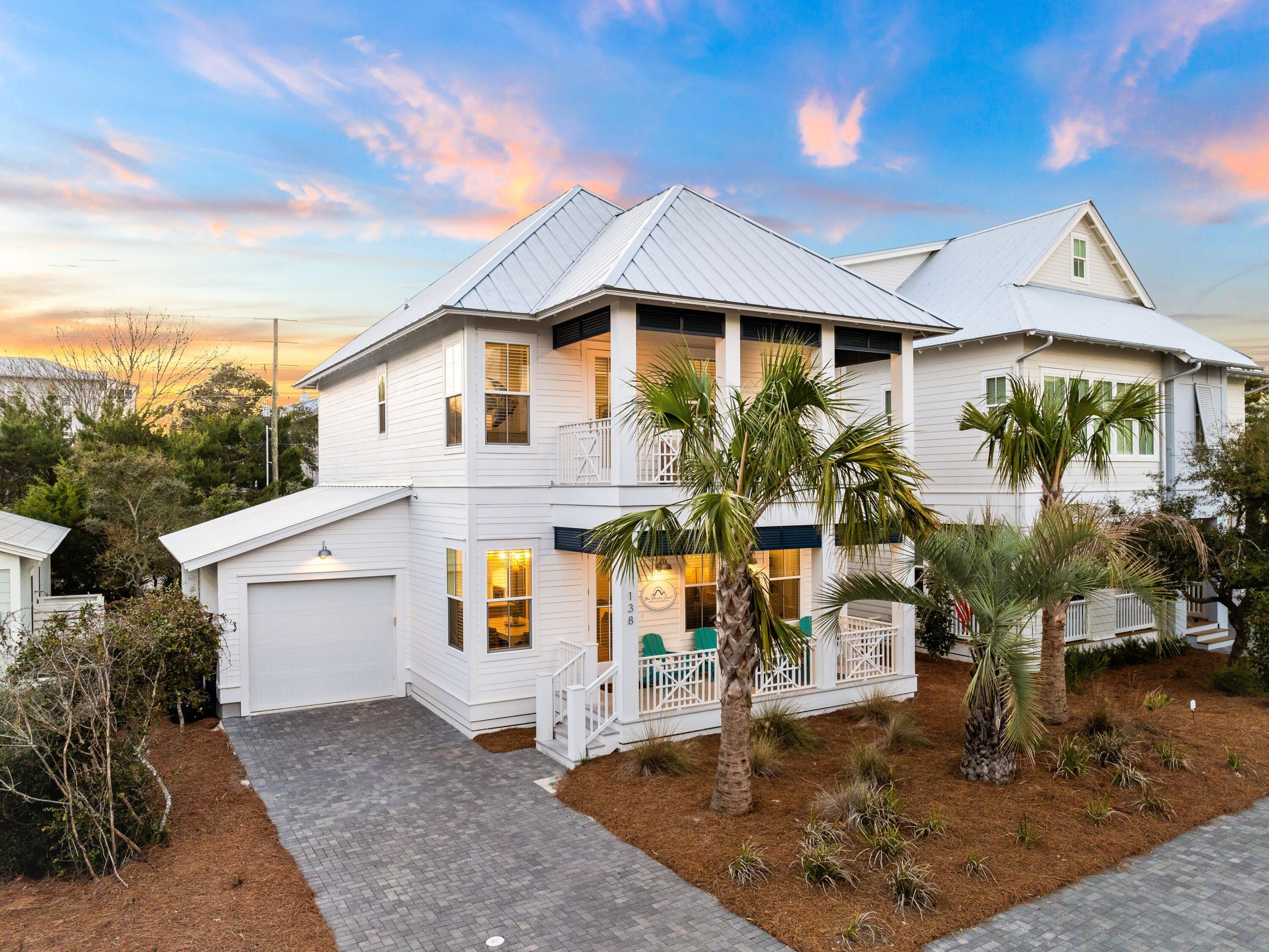 Tucked away in Lakeside at Blue Mountain, this custom home boasts a premier finish with hardwood flooring, design tile, custom lighting and a master suite on both floors. Built in 2022 and lightly used, the entire four-bed, four-bath home still feels brand new. The deep front porch is the perfect spot to gather at the end of the day. Sip your favorite drinks and share gossip while enjoying the sun-kissed skies and refreshing sea breeze. Inside, the home has an open living room leading into the well-appointed dining kitchen. White quartz countertops show off the luxury cabinets and high-quality appliances, including a six-burner gas range. The kitchen island has stools for serving drinks and snacks beside the formal dining table. Wood-tread stairs ascend to the second master suite, along with another guest bedroom and a coastal-themed bunk room. An additional porch provides a quiet place to enjoy a cup of coffee as you start or end the day. Built-in bunks give youngsters their own cozy space for sleeping and playing. Three full baths plus a half bath are beautifully appointed with designer tile. Rounding off the space, there's a laundry room and an attached garage for storing bikes and beach toys. Outside, lush palm trees and new low-maintenance landscaping provide the home with shady, tropical ambiance. The nearby community pool is seasonally heated for family fun. The white sandy beach and emerald Gulf of Mexico are a short walk or bike ride away. Hop on bikes and cycle to Seaside, Florida, and WaterColor for brunch or boutique shopping. There's a beautiful paved bike path the whole way so you can burn off calories consumed at popular restaurants such as Redfish Taco, Blue Mountain Creamery, For the Health of It, Johnny McTighe's Irish Pub and more. This home encapsulates the best of Blue Mountain Beach living with a laid-back lifestyle that's hard to beat. 