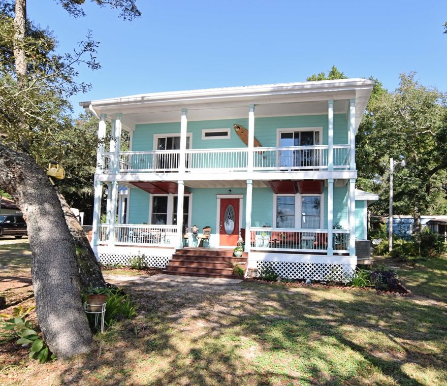 This lovely home offers magnificent water views from every room! Imagine going through your day watching the surface of the Bay changing from still and smooth as glass to gentle waves. The dolphins play and the clouds reflect like artwork just outside of your home!The charm of this home starts the moment you drive up- from the beachy exterior colors to the wide porch and balcony, to the surfboard mailbox, the entire home beckons you inside.As you enter the home, you are greeted with a large open space full of windows. The family room is large with a cozy alcove, perfect for a reading nook or a grand piano. The dining area shares the space and is open to the kitchen, where the breakfast bar is a good place to finish homework or keep the family cook company as they work. The laundry roo