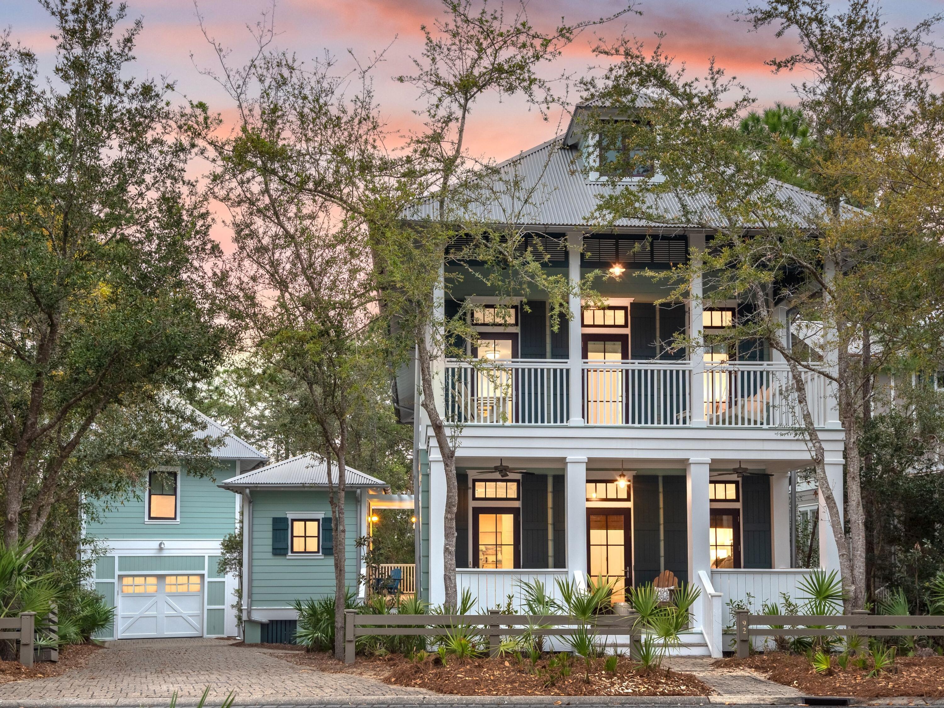 Recently renovated to the highest standards, this Southern-style home has shady, covered porches on both levels. Backing on to preserve land with mature pine trees, it enjoys a sense of privacy yet is just two blocks from Camp WaterColor fun. The open-concept living space has dark wood effect flooring countering the high ceilings, white decor and transom windows delivering an abundance of natural light. The chef's kitchen has been beautifully updated with a full range of stainless appliances and a beverage bar. Quartz countertops extend over the generous island which easily accommodates five diners at the breakfast bar and overlooks the cozy living room completed with fireplace.