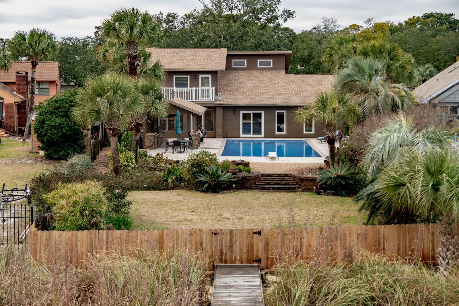 STUNNING WATERFRONT HOME WITH POOL, BOAT SLIPS, AND OUTDOOR SPACE.Nestled on Lake Clyde, a deep-water saltwater lake in Shalimar, Florida with direct access to the bay and ultimately the Gulf of Mexico and some of the finest fishing around. This home brings charm, warmth and is the perfect property for the saltwater enthusiast.  The property features two private boat slips, along with a spacious sun deck--perfect for sunbathing, relaxing, or enjoying breathtaking views of the water.The backyard is expansive; complete with a huge pool, fully equipped outdoor kitchen  with a natural gas grill and broiler for your next shrimp boil. The backyard has been cultivated by a master gardener to feature mature flowers, plants and palm trees.  It's your own tropical paradise. Stepping in from the backyard you are greeted into the Florida room which is a fantastic place to sip your cup of coffee in the morning or enjoy a relaxing evening. 
The kitchen is spacious. There is plenty of space to serve guests and tons of cabinets to store away all your cookware. Just off the kitchen is the living room with 12ft stained cedar ceilings that bring warmth to the space.  The living room has plenty of space for your oversized seating and even has a bonus room just off the living room that is currently being used as a music room with even more cabinets and storage.  The living room is home to the gas fireplace and entertainment equipment that fuels the indoor and outdoor speakers.  
Just off the living room is the master suite (1st floor) and large tranquil master bathroom with his and her closets.  You will LOVE the oversized custom designed river rock shower- beautiful and functional. 
Also, on the 1st floor you will find the laundry room and a good-sized office just off the 2-car garage. 
Upstairs, you'll find a versatile loft space ideal for a home office, reading nook, or additional living area and 2 bedrooms.  Your guest/family can draw straws on whoever gets the bedroom with their own private balcony.  
The seller has gone above and beyond meticulously maintaining the property. Roof is 2024. The pool has a brand-new pool liner.  The sellers purchased an Aqua Dam that will convey with the property to protect the property and pool from any rising waters from the bay. Security system in place with ADT. This home truly offers the ultimate in waterfront living, with all the amenities and details you could want for a luxurious, relaxed lifestyle.
