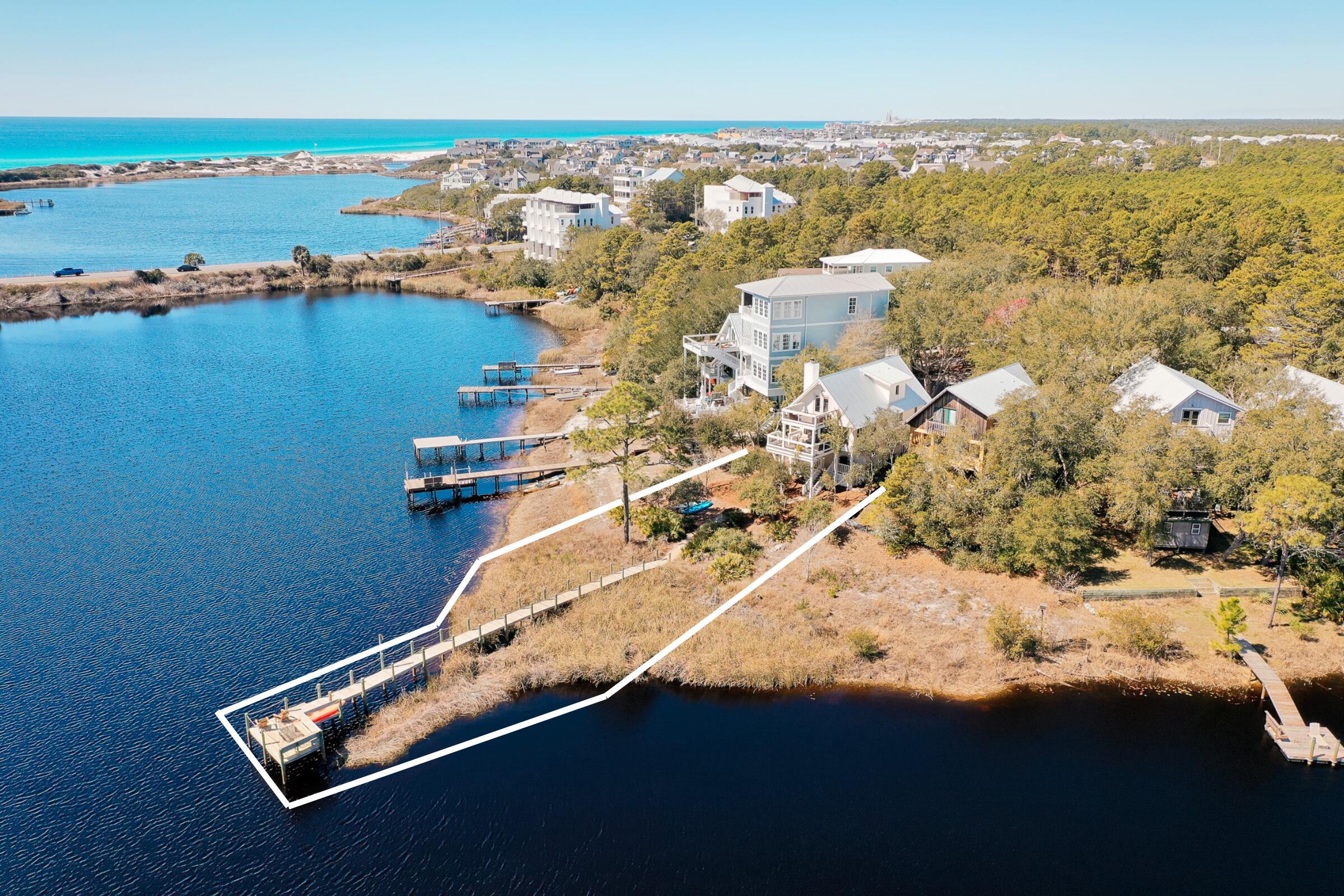 Overlooking the breathtaking views of Camp Creek Lake and the Gulf, this iconic water-front home provides an unprecedented opportunity to enjoy the perfect blend of lake and beach lifestyle rarely found along the Emerald Coast.This three-bedroom, two-and-a-half-bathroom home is designed for effortless coastal living. Upon entry, you are greeted with the warmth of a wood-burning fireplace in the perfectly designed main living area. Moving into the expertly upgraded kitchen that seamlessly flows into a dining and sunroom offering panoramic views over the coastal dune lake, creating the perfect setting for dining or unwinding with nature as your backdrop... Stepping out onto the covered porch, you will enjoy the warm breeze coming off the Gulf while overlooking the sunshine cascading off the waters below. With a true master-suite off the main living area and two additional bedrooms on the second floor, this home boasts opportunities to enjoy lake-front scenery as well as views over 30A and into the Gulf with friends and family.
Take advantage of the private walkway to your extended dock offering immediate access to enjoy the water-front lifestyle. Having both a garage and carport, this home makes storage easy whether you're parking your car or putting away your kayaks and paddle boards after a day at the beach or on the lake.
With Gulf views, direct access to the Watersound Beach Club via boat or kayak, plus a full set of build plans to add an additional 600SF of living space below creating a five bedroom waterfront oasis, this property provides ample opportunities for long-lasting memories in coastal paradise.
Inquire today to begin living the coastal lifestyle you deserve.