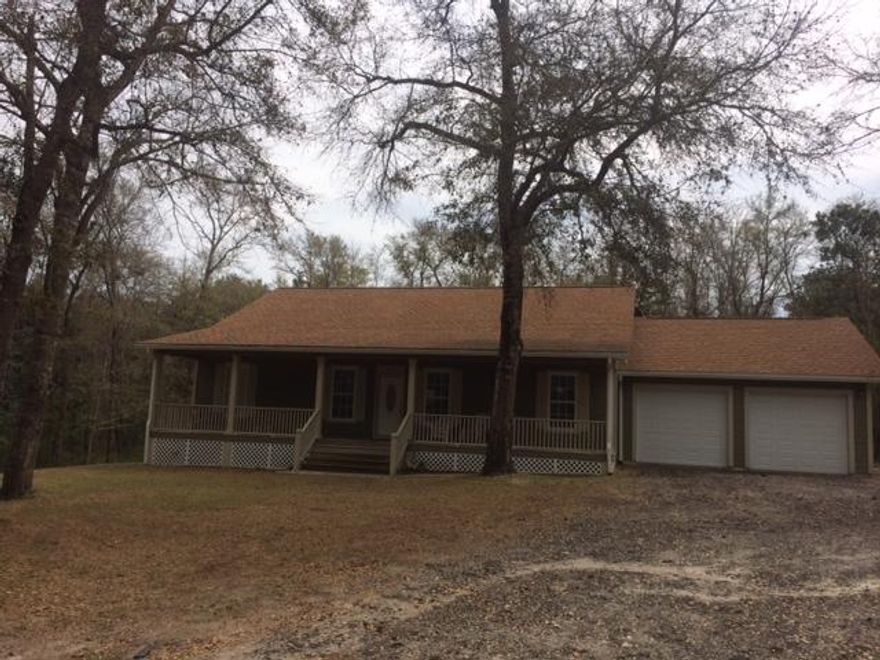 Private and serene! This beautiful home sits on over one acre, and backs up to wooded parcels. There is a small creek on the property, and you can enjoy the peaceful setting from one of two porches, as there are large porches located both on the front and the back of the home. The home features hardwood floors in the living room, carpet in the bedrooms, and travertine tile in the kitchen, laundry and bedrooms. Beautiful custom cabinets complete the mastery of this home. Enjoy an oversized two-car garage, as well--you have to see this home inside and out to believe it!All measurements are approximate and should be verified by the buyer.
