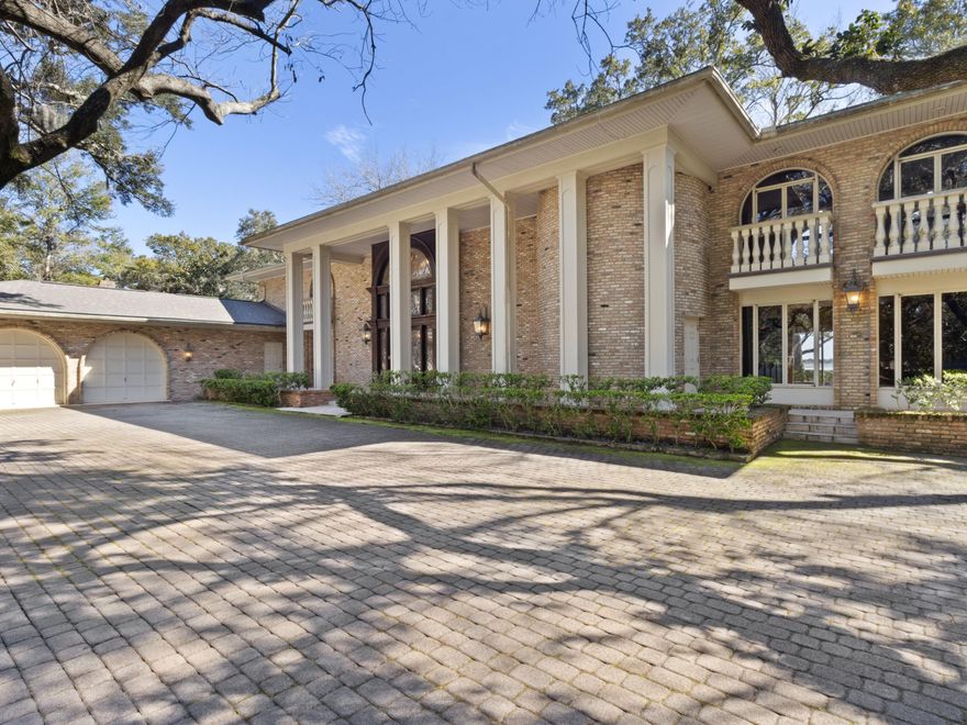 Tucked away on 2.75 acres along the Santa Rosa Sound, this stately waterfront estate offers an extraordinary combination of privacy, deep water access and breathtaking views of the barrier islands and the gulf. A 600-foot oak-lined driveway leads to this impressive 5,120-square-foot Old Chicago brick home, where timeless elegance meets the beauty of the Intracoastal Waterway.  With 150 feet of private sandy beach and deep water frontage, this property provides unparalleled access to the water. Whether launching a kayak, paddleboard or jet ski right from your backyard or simply enjoying the serenity of the water from the verandas, this is a retreat like no other.  Inside, architectural details abound. Crystal chandeliers, imported mahogany millwork, and soaring 25-ft. ceilings frame a home built for both grandeur and comfort. A wall of windows in the main living area captures stunning water views, while three fireplaces add warmth and charm. The primary suite is a private sanctuary, complete with a fireplace, balcony and an opulent dressing area. A library with a wet bar offers a quiet escape, and the kitchen is equipped with designer Sub-Zero and Thermador appliances, including warming and refrigeration drawers.  

Outdoor living is equally remarkable with covered porches, open patios and a separate artist studio, all set against the backdrop of sweeping waterfront vistas. The gated entrance and long paver driveway enhance the estate's exclusivity.  

For those seeking a private deepwater retreat, this property offers an unparalleled lifestyle. Alternatively, its expansive acreage presents an exceptional development opportunity, with potential for multiple waterfront homesites and additional residences with water access. Whether as a grand estate or an exclusive residential enclave, this Mary Esther property is a rare and remarkable find.