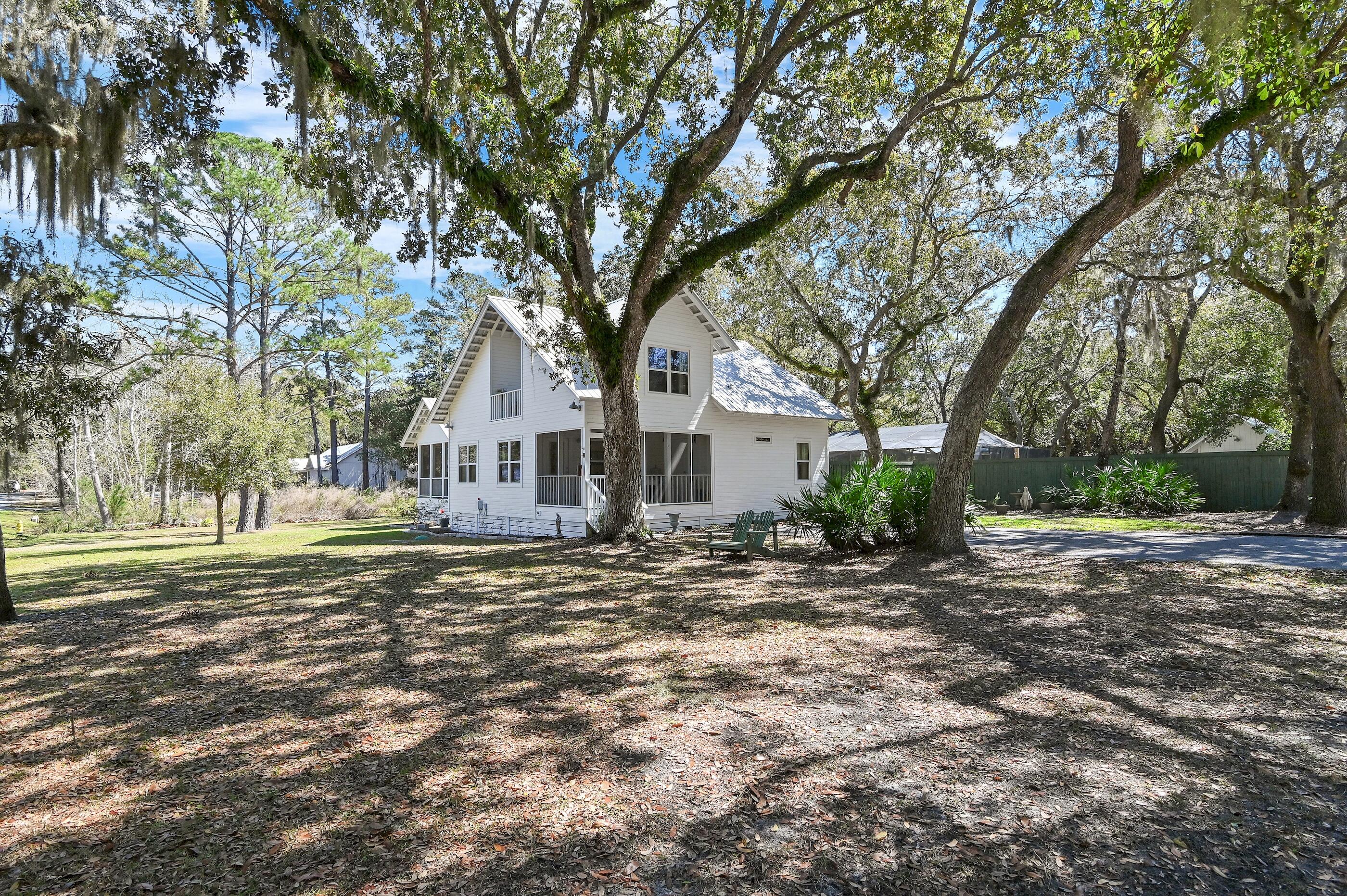 New offering in coveted, Historic Pt. Washington! Like new 4 BR, 3 BA Florida Cottage featuring heated 'sports pool' all nestled on premiere Bay view location. Corner, 1 acre, low traffic site is blanketed with majestic hardwood shade trees providing plenty of room for expansion (e.g. carriage house, garage, RV parking and more). Seaside style cottage totally renovated 2018-2019 including galvalume metal roof, heat pump, doors and windows. Main Suite added 2020. Expansive wooded deck (over 2,400 sq') covers back yard area between house & pool. A detached workshop/storage building is practical for storing lawn, fishing, beach & bay gear. Extra amenities include fire pit/patio area, hammock, 3 outdoor showers. County Park/Bay access just across E. Mitchell Ave approx. 150 yards. NO HOA!