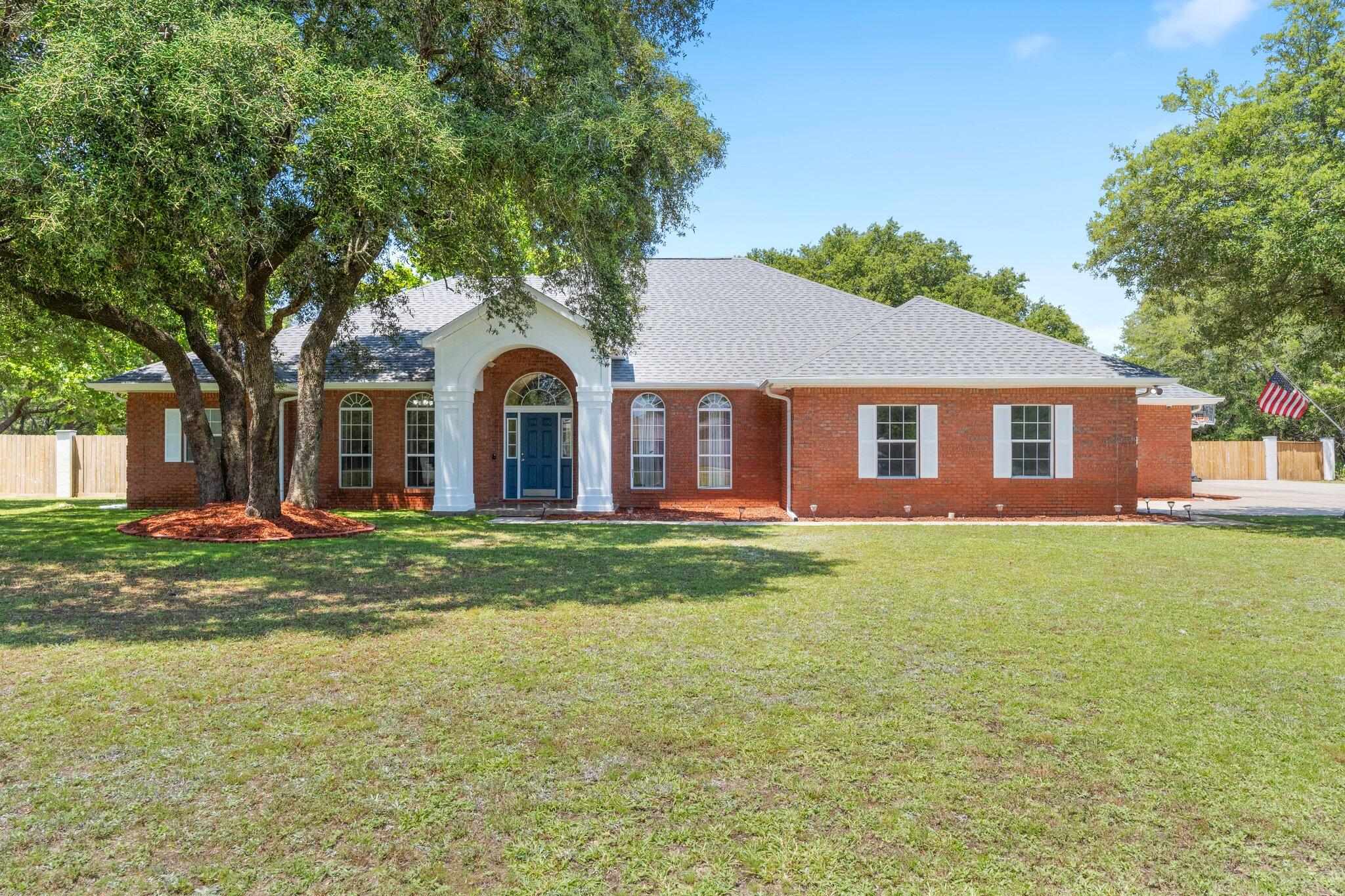 This is your chance to own your slice of paradise just minutes from Navarre Beach. This brick home features an impressive 3,414 sq ft of living space and over 1,000 sq ft of garage space and sits on a unique 1.3 acre property with no HOA! Bring your RV or boat! Inside you have 12 and 9 foot ceilings, formal dining room and office, large island in the kitchen and a breakfast nook overlooking the impressive living room with a fireplace. Master suite has 2 walk in closets, huge bathroom with whirlpool tub and large walk-in shower and a second water heater for the master. The split floor plan offers 3 more bedrooms on the opposite end of the house. An impressive sized sun room, walk out to your huge, fully fenced back yard, detached garage, storage shed, custom playset, gazebo and more!