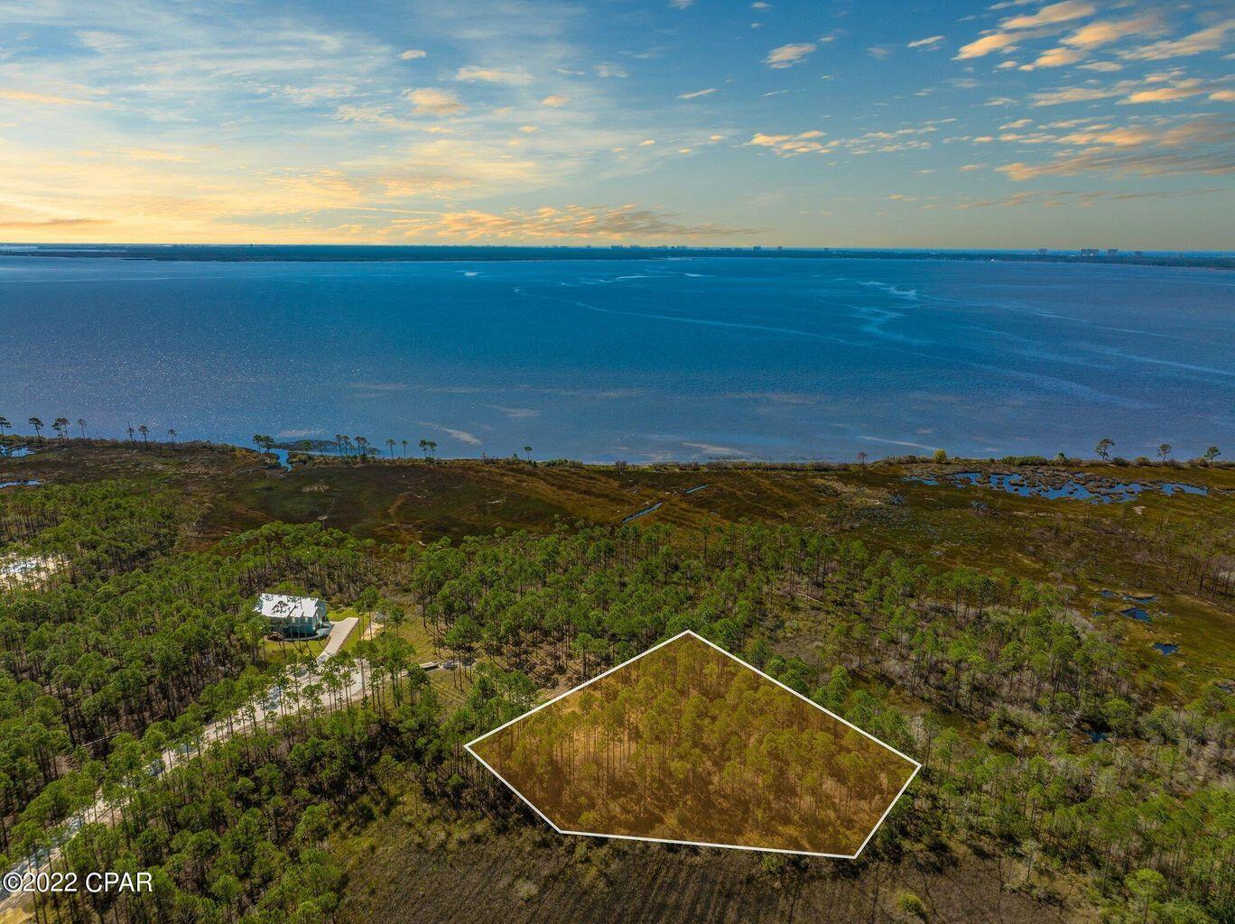 If you have never been out to the St. Joe community, Rivercamps on Crooked Creek, you will be mesmerized! Surrounded by 3 bodies of water, Crooked Creek, the Bay and the Intercoastal Waterway, this peaceful community is a nature enthusiast and boater's dream. Plenty of space and privacy and yet so close to all the conveniences one could want; only 15 minutes to the beach or Pier Park with over 100 stores, eateries and entertainment, 10 minutes to the airport and the planned new hospital and Publix also within 10 minutes. Build your dream home on this prime 1.29 acre waterfront end lot with beautiful Bay views. No other homes will be built in front, behind or on the east side. Rivercamps owners and guests enjoy world class amenities not found in any other community including... boat storage, 2 boat launch ramps, 8 daytime boat docks, a gorgeous large waterfront community center with a fully stocked commercial kitchen for parties and community events, state of the art fitness center, pool table, zero-entry pool, hot tub, firepit, barbecue area, pickle-ball court, playground, volleyball, adorable campsite with TP's and restrooms, bikes, paddle boards and kayaks for owners and guests use, 7 miles of trails and boardwalks all included in the HOA! For additional information on RiverCamps on Crooked Creek: https://www.joe.com/community/rivercamps