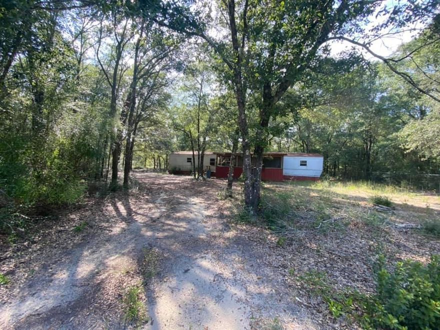 Land for sale with electric, water and septic! This 2.2 acres has some cleared areas as well as wonderful oaks throughout. Approximately one acre of the land is fenced and has a 2/2 1984 mobile home on the property. This would be a great development property!! Come and see it today!