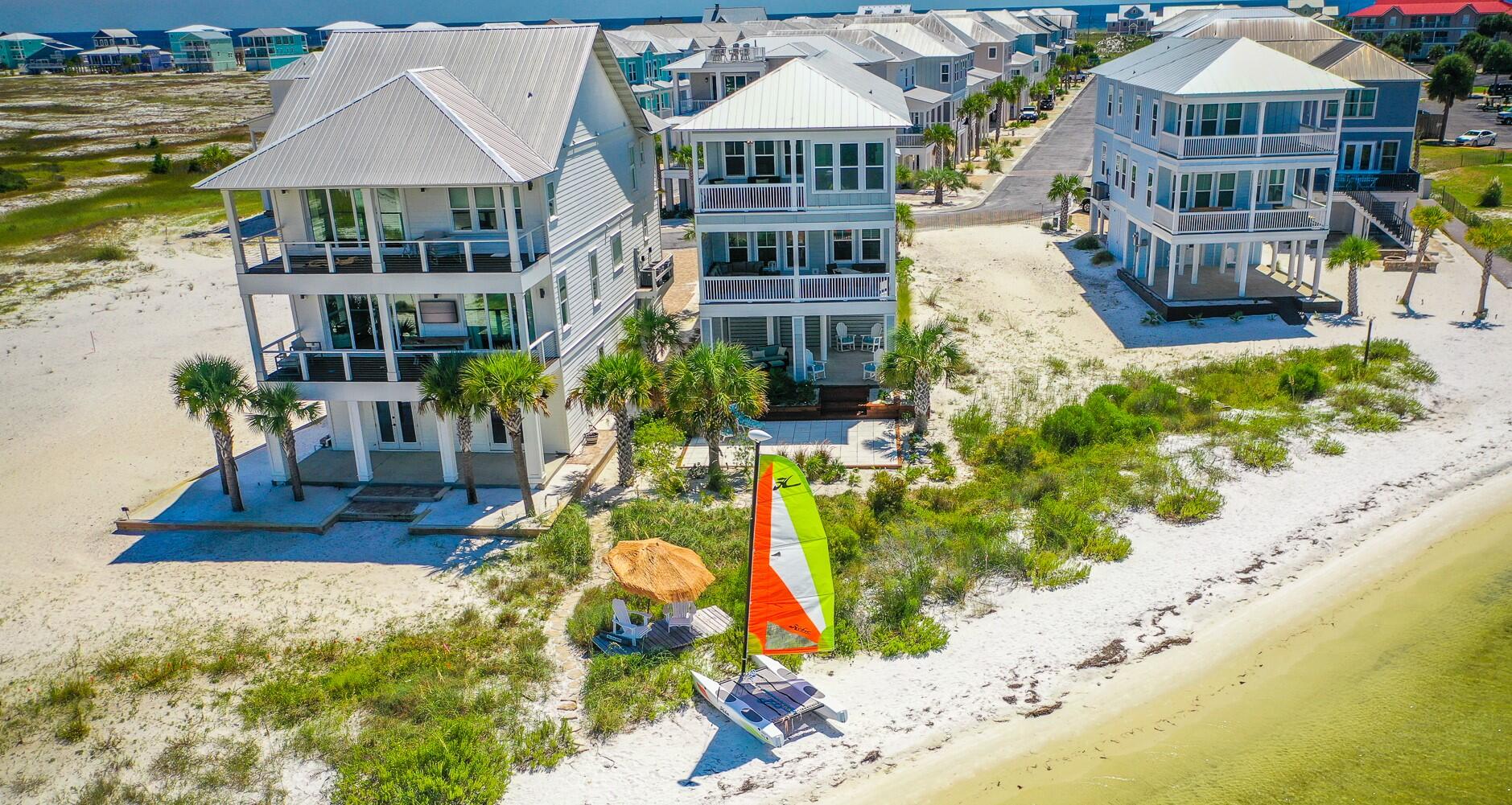 RESORT-STYLE ISLAND LIVING at its best in your beautiful customized waterfront home! Whether you're looking for a SMART RENTAL INVESTMENT (We have a projection for $150,000 annually!) that can house three families or a primary/secondary home, this luxury beach house is perfect! Located on the sugar white sandy beach of Santa Rosa Island, enjoy breathtaking water views of the Santa Rosa Sound from every window. You and your guests can go sailing at sunrise, jet skiing at lunch and paddle boarding in the afternoon with ease, as every recreation is right outside your back door! Paddle boards, fishing equipment and the Hobie Wave sailboat are all included. Celebrate large family reunions around a fire on your enormous back patio surrounded by exotic palm trees and tropical plants.