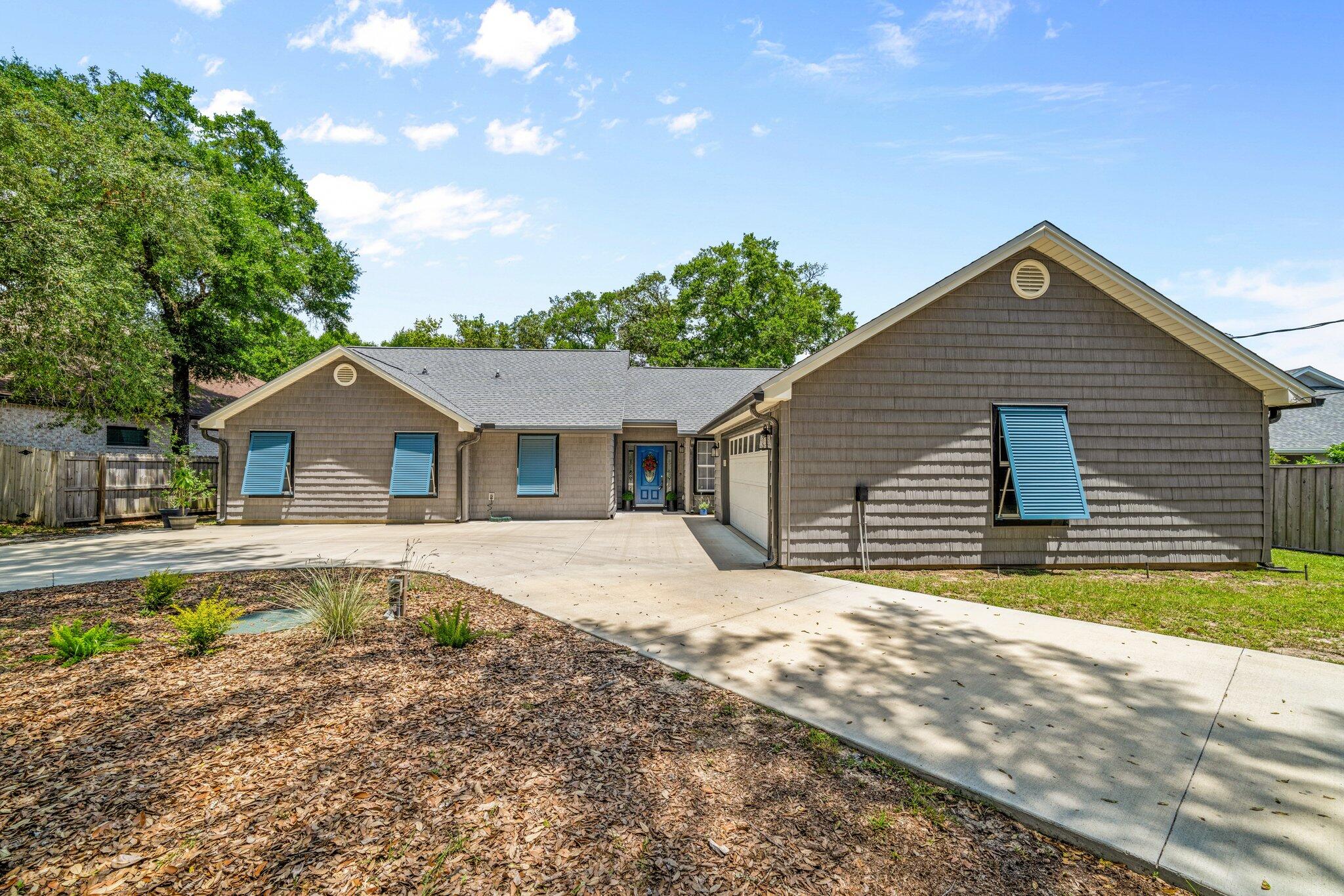 Fully renovated home located in Shalimar, FL just a block from Santa Rosa Sound beach access! Launch your paddle boards, canoes or go fishing! This 1853 sq foot home has 4 bedrooms and 2 baths and has been updated throughout! This home features a new roof (2023), HVAC system (2024), and gas, tankless hot water system (2024). Enter the lovely foyer and notice an open floor plan with the kitchen opening to the living room and kitchen areas. The kitchen features new custom cabinetry and crown. There is custom cabinet hardware and soft close drawers! The kitchen also features a custom tiled backsplash, new gold faucet and new recessed lighting. The appliances were updated to include a side by side refrigerator with icemaker with water, a slide in electric stove/oven, rangehood, microwave, and dishwasher. All appliances are stainless and black. The cabinets are modern shaker style with white uppers and beautiful blue lower cabinets. There is a peninsula or breakfast bar that seats up to 4 or 5 guests! The exquisite quartz counter tops and custom wood columns and ceiling beam finishes off this gorgeous kitchen design! The kitchen opens to an eat in kitchen area that could also be a home office! There is additional custom lighting with pendant lighting over the peninsula and a custom chandelier over the eat in kitchen area! The dining room is large enough for a 10 to 12 person dining room table! This area also has large picturesque windows overlooking the fenced back yard and open deck! The living room features vaulted ceilings, recessed lighting, a new custom ceiling fan, and a gas fireplace (2025) with a mantel and white vertical shiplap wall covering! The entire home has wide plank luxury vinyl plank flooring. The primary bedroom is very large and features recessed lighting, a custom ceiling fan and an updated ensuite bathroom. The primary bathroom has a new custom tiled walk in shower, new double vanity with quartz counter tops and under mount sink, a separate water closet and a large walk in closet! The primary shower features a niche, shower bench with a quartz seat and new shower faucets! No detail was missed in this home with over $10,000 spent on custom closet systems, new hardware on doors and cabinets, mirrors, new vanity lighting and faucets in the updated bathrooms. There are three additional guest bedrooms and a fully updated guest bathroom! Finally, the interior of the home features a laundry room with a sink basin! The interior has been professionally painted with new base molding, and lighting throughout. The exterior was also updated to include all new exterior custom Colonial Grey shaker vinyl siding, new concrete circular driveway, Military Blue Bahama shutters for the front windows, a Sentricon Preventative System that is monitored, and new connection to public sewer. The homeowner also had the Ducts cleaned by NADCA certified contractor Advantaclean. There is gas available for grilling on the open deck, exterior new gutters with a leaf guard, and a oversized two car garage. The shed is adorable and perfect as a he or she shed. There are two public beaches within a few blocks of this home! Buyer to verify all dimensions and information!