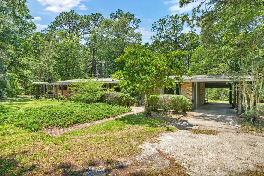 This truly special - one of a kind - legacy property is now available in Holley!  Originally settling this area in the late 1800's, this 2.85 acre parcel was passed down through this family until the home was finally built in 1959.  The home is custom built by the original owner - from the front door, to the intricate trim & built in storage throughout - showcasing the original owners master craftsmanship and attention to detail. The front living room features sun-room, fireplace & built ins and flows through to the dining area and kitchen. The front two bedrooms share the main bath, with third bedroom & ensuite accessed through rear hall. The large screened in porch lies just off the rear family room, with built in storage & full wrap around porch covered with mature jasmine.  A second carport lies in the rear along with the shop, garden and additional coverage for boat storage.  The designated garden area is approximately 54' x 78' with additional pear and persimmon trees. Immediately behind the shop/garden is a mature pine grove, hand planted by the original owner.  This truly unique property will not last long! - Schedule your private tour today! *Buyer/Buyers Agent to verify all information is deemed accurate and correct. Property being sold AS-IS