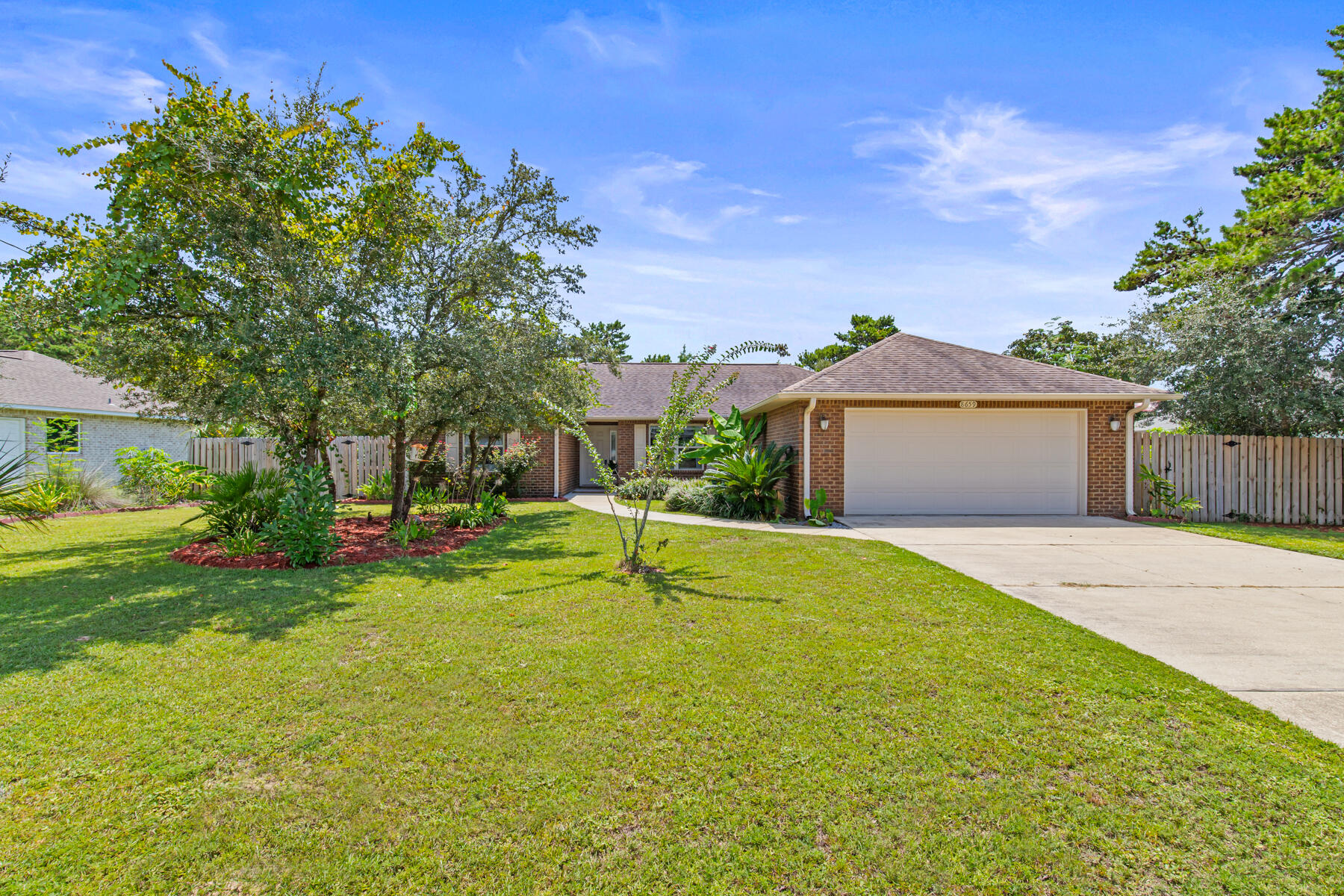 Fall in love with this vibrant, move-in-ready gem with no HOA! On a half-acre lot, this 2,024 sq ft stunner boasts 4 beds, 2 baths, and a spacious 2-car garage. The split floor plan ensures privacy, while the great room, with soaring ceilings and a fan, opens to a 10x16 covered porch-perfect for chilling. The kitchen dazzles with granite counters, custom cabinets, and stainless steel appliances. Your master suite is a cozy retreat with a spa-like bath featuring dual vanities and a huge shower. LVP flooring and tile throughout wet areas. The expansive backyard offers a beautiful and lush garden. Just half a mile from shops, eateries, and the serene bay, and minutes from the gorgeous beaches, this is your dream home waiting to happen! Call for details!