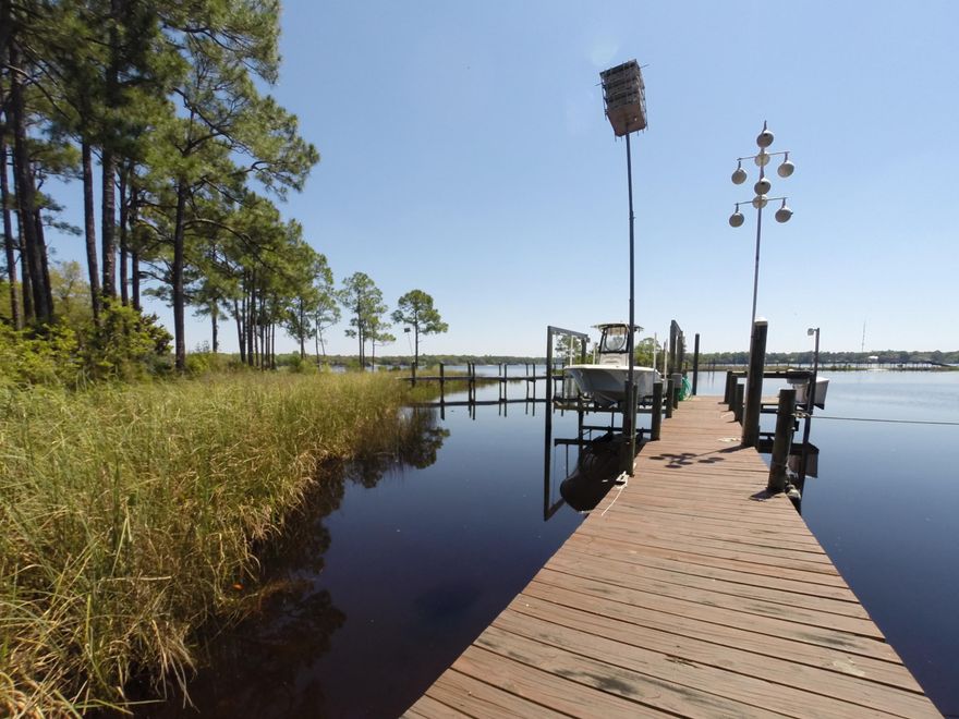 Absolutely gorgeous WATERFRONT property located on a protected cove on Rocky Bayou, large 1/2 acre lot, over 11' elevation! No bridges & 15 minutes to east pass. W/ 100+ ft. of waterfront, you have tons of room for your water toys - dock (2003) w/10,000 lb lift, fish cleaning station, & extra pilings to tie up a sailboat or other boat. This waterfront home is true serenity! Western Red Cedar Board & Batten siding, durable metal roof (2006), impact windows/doors on back of home (2006),paver driveway (2010), & so much character. Incredible large oak trees and lots of room for your RV or boat trailer! When you enter the home, you will be welcomed through the new front doors into the beautiful light filled 2-story foyer. 4 bed, 2.5 baths, updated hardwood flooring in main areas, amazing views