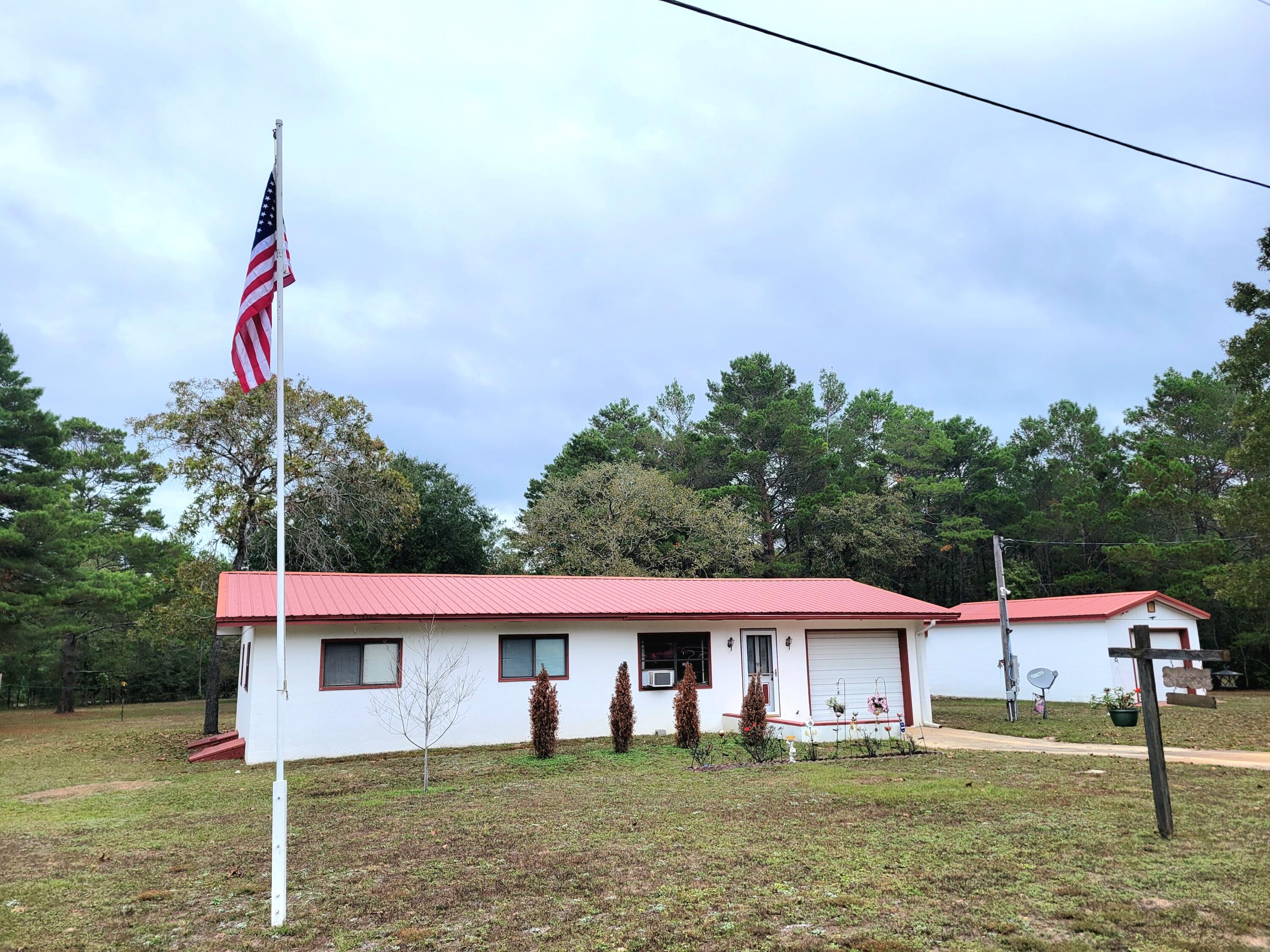 Country Home on two lots  appx. 1040 sf house plus a single car garage  all block with stucco finish. and a separate 592 s.f. block workshop is a super buy!  Built off grade with 9'' crawl space with concrete floor under the house.  Window air and wall heat.  Central air and heat could be added easily.  Metal roof and a comfortable floor plan. Has a new back deck. This property could be expanded possibly if needed for extra family members (subject to building department permitting).  There is electrical 30amp and septic tap in place for an RV between large shop building and the house.Click on ''DOCUMENT'' TAB for survey  and other information.   There are 8 adjoining listed separately near house if you have need of more land.