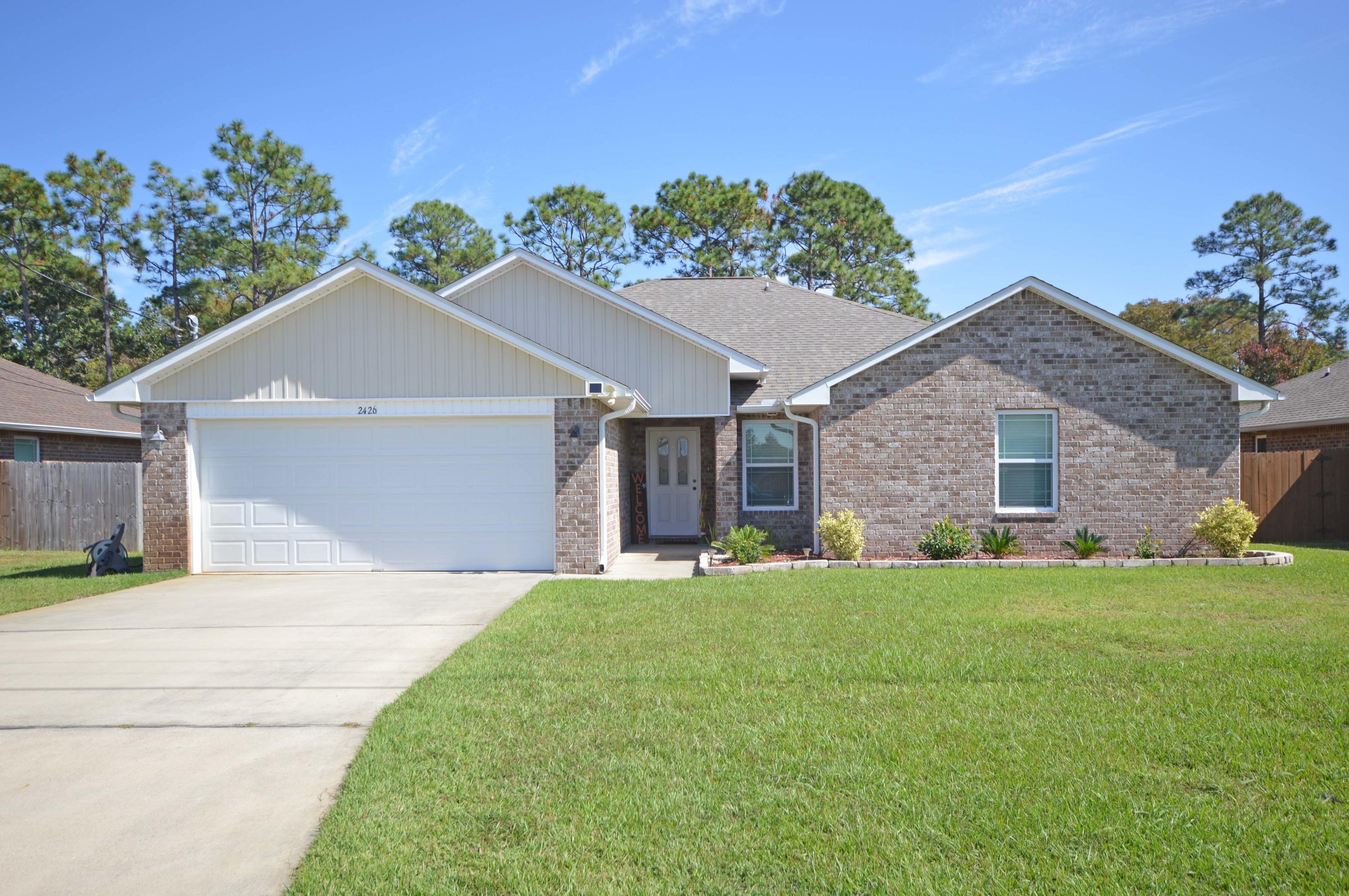Welcome home to this fantastic 4 bedroom home located in Navarre close to schools, beaches and shopping! All brick home boast a large spacious living/family room with high ceilings and plant ledges! The kitchen is open and perfect for entertaining with a breakfast nook adjoining! The large kitchen has beautiful custom cabinets, tile floors, smooth top stove, upgraded faucets plus stainless steel appliances! The split floor plan has 3 additional bedrooms on another wing for privacy and quiet! Master bedroom has a trey ceiling and double windows looking out to the peaceful privacy fenced backyard with Extra Large Patio; Master bath has his and hers walk in closets and a garden tub with separate shower; Tile floors; The master bath has double vanities for privacy and convenience; Additional