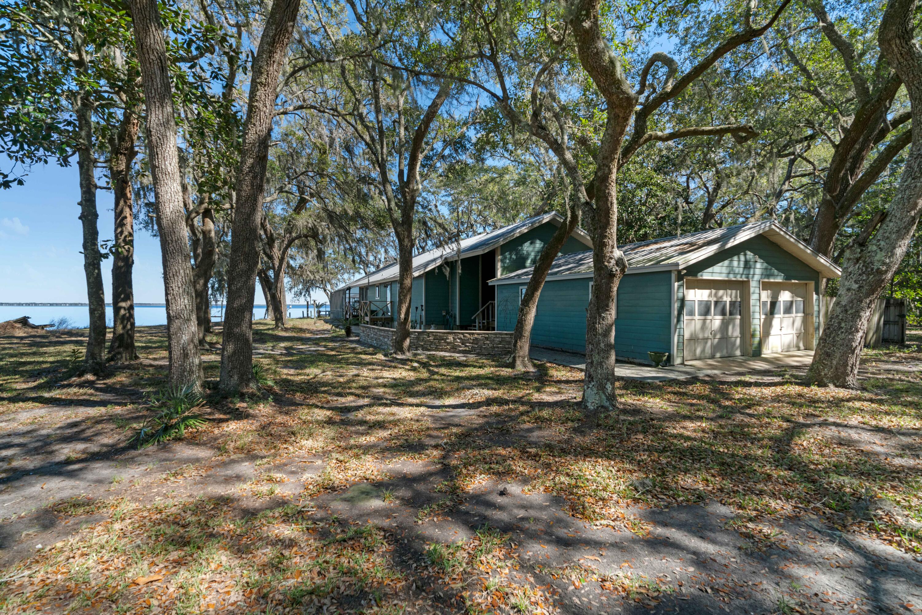 This amazing bay front home gives the feeling of being out in the country with no roof tops in sight to the serenity of the salty air and multiple species of marine life frolicking in the water in front of this amazing property.  Only a short drive to some of the worlds most amazing beaches, shopping and some of the best restaurants along the gulf coast.  This three bedroom/three bathroom Florida cottage is surrounded with large live oak trees.  There is a seawall that protects the property from erosion and you will experience some of the most amazing sunsets and sunrises imaginable.  There is approximately .6 acres associated with this property with the availability to also purchase the 1.2 acres that is directly attached to this property to the west.