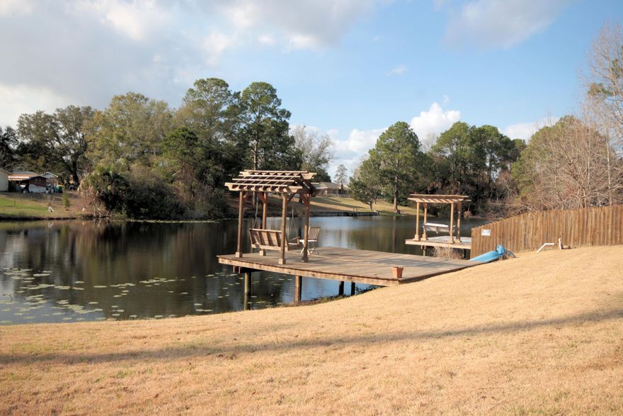 Always feel like you are on vacation in this quaint 1885 ft. cottage. It is situated on a lake stocked with fish waiting to jump on your hook! Have your first cup of coffee on the swing under the pergola on the dock, looking out over the lily pads. Or wind down after a long day in your hot tub under the covered screened in porch. When you do decide to leave your haven, the convenience of town is just around the corner. The large fenced in back yard provides plenty of privacy and room to play. Tuck all your tools and equipment away, secure and dry, in the large shed, also enclosed in the fence. The front yard is landscaped with beautifully blooming pollinator friendly plants. Have plenty of room for guests to park and pull away from the home safely using the pull through circular driveway.
The custom details of this gorgeous home start at the welcoming entrance. The stone base of the columns and house not only add charm, but double as protection to the home. Custom built shelves start at the front door and are woven throughout the whole home, creating perfect nooks for your favorite trinkets and books.
The cleverly designed open floor plan makes the most of the space, natural light and stunning view. From the kitchen, dining room and living room, you can see the backyard and lake through the large picturesque windows on both sides of the gas fireplace. You'll actually enjoy whipping up gourmet meals in this bright, cheery and efficient kitchen. The quartz countertops continue onto the huge island, hugging the farmhouse sink and opening up to the wrap around breakfast bar. Beautiful wood grain ceramic tile run throughout the entire home, giving it a coastal rustic feel with zero maintenance and super easy clean up! Both bathrooms have separate water closets, for that added privacy and solace. Keep the laundry quiet and out of sight in the separate laundry/mud room.
Special features include crown molding, Ultra light for allergies on heat/air with 2 air vents, Alarm, Hurricane Shutters, floored over garage and Plugs on the eaves of the home for Christmas lights.
A lot of love and thought went into designing and building this gorgeous home. Come see all the special details for yourself and what its like to live on vacation