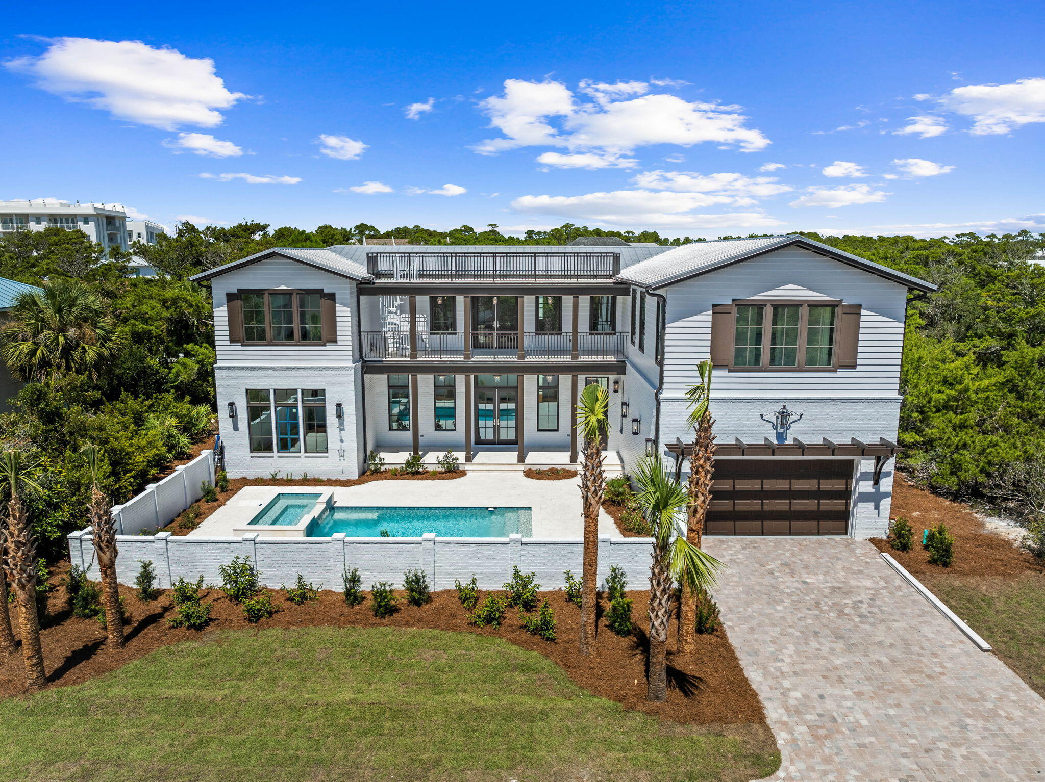 Indulge in the ultimate luxury coastal living experience with this exquisite new construction house located in the non-rental gated neighborhood of Sand Cliffs. Designed for those who appreciate fine living, this home offers deeded beach access and a stunning array of high-end features, including wire-brushed white oak hardwood floors, upscale appliances, an ice maker, wet bar, wine refrigerator, and two laundry areas. The house was designed with entertainment in mind.    The U-shaped design gracefully encloses a spacious saltwater pool, hot tub, and expansive deck, offering a private sanctuary for relaxation and gatherings.  There is a large living space upstairs that could be used as a game room along with a separate media room.