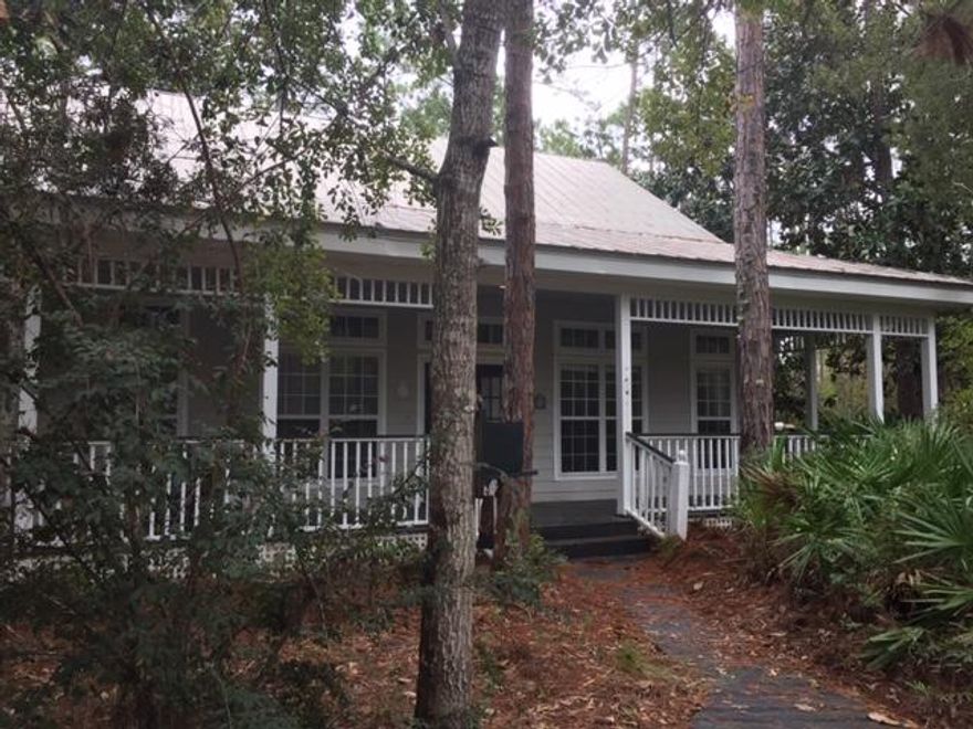 Welcome to ''The Woods''Florida cottage style home with guest cottage is just what your clients are looking for! Entering the main house through large opened wrap around porch, the bright open floor plan welcomes you with large windows and French doors. The spacious kitchen overlooks the back screened porch and beautiful woods. The large master bedroom suite,with walk in closet and bath with double sinks, has plenty of storage. The second bedroom has its own private bathroom and shower.The carriage house above the 2 car garage has a 1 bedroom suite complete with office and storage and private parking.Property is very private with a circular driveway and beautiful trees.