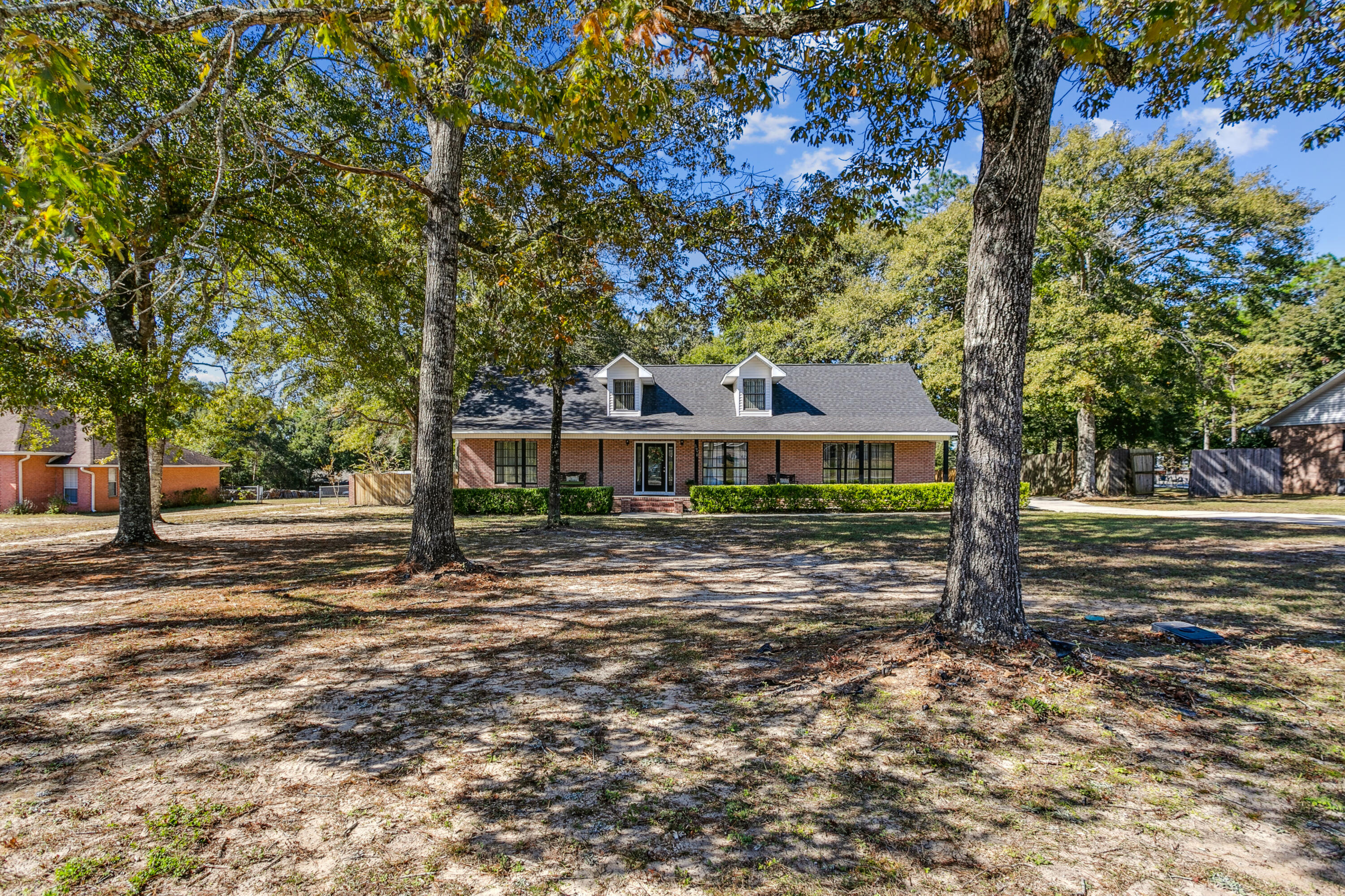 Well-loved custom home sitting on almost a full acre. You will be amazed at this gorgeous porch that spans the full length of the house! Walking through the front door, you will immediately notice the open and airy floor plan. The oversized living room can accommodate a large sectional. Looking through the living room, you can see the bright Florida room that overlooks the large backyard. The kitchen is located right off the dining area which makes entertaining a breeze. The primary bathroom features a garden tub, separate shower and a double sink vanity. The other side of the home has 2 bedrooms with a Jack and Jill Bath. The upstairs bedroom could be an AirBnB or office. The home has a 2-car carport as well as a detached 25x25 garage. Don't wait to see this one-of-a-kind home!