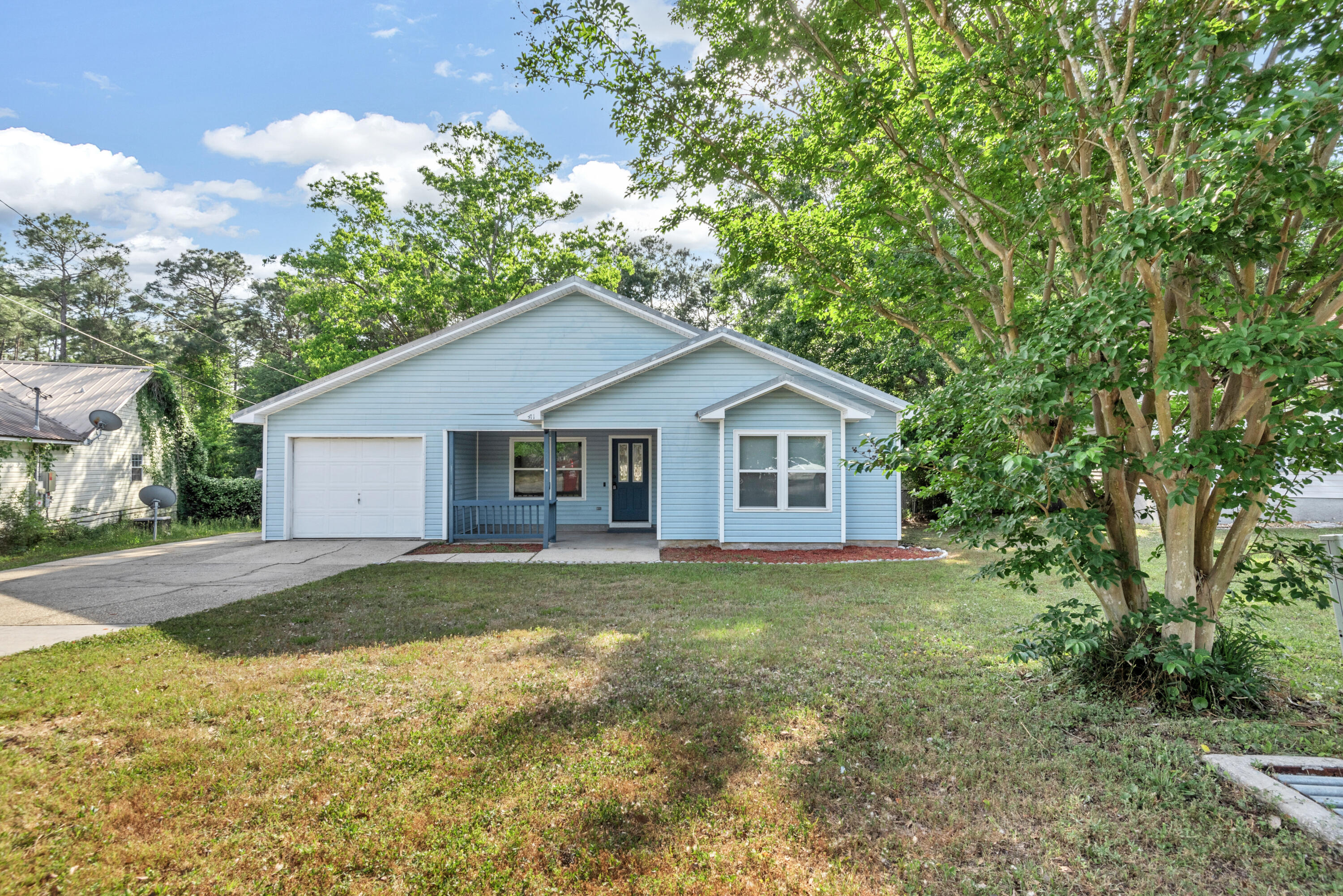Great location South of I-10 with easy access to I-10 as well as a short drive to the bases. This home is light and airy and has a large amount of useable space.  With the split floor plan the Master is set off to allow for added privacy and features a large walkin closet. The home location backs up to a tranquil wooded area for privacy. A large concrete patio area off the back of the home allows plenty of room for entertaining and just relaxing. The kitchen has granite counters with undermount sink and white cabinets to continue the light feel of this home. Both additional bedrooms have good sized closets. An additional concrete parking area gives more off-street parking.  The home has great curb appeal with the covered front porch